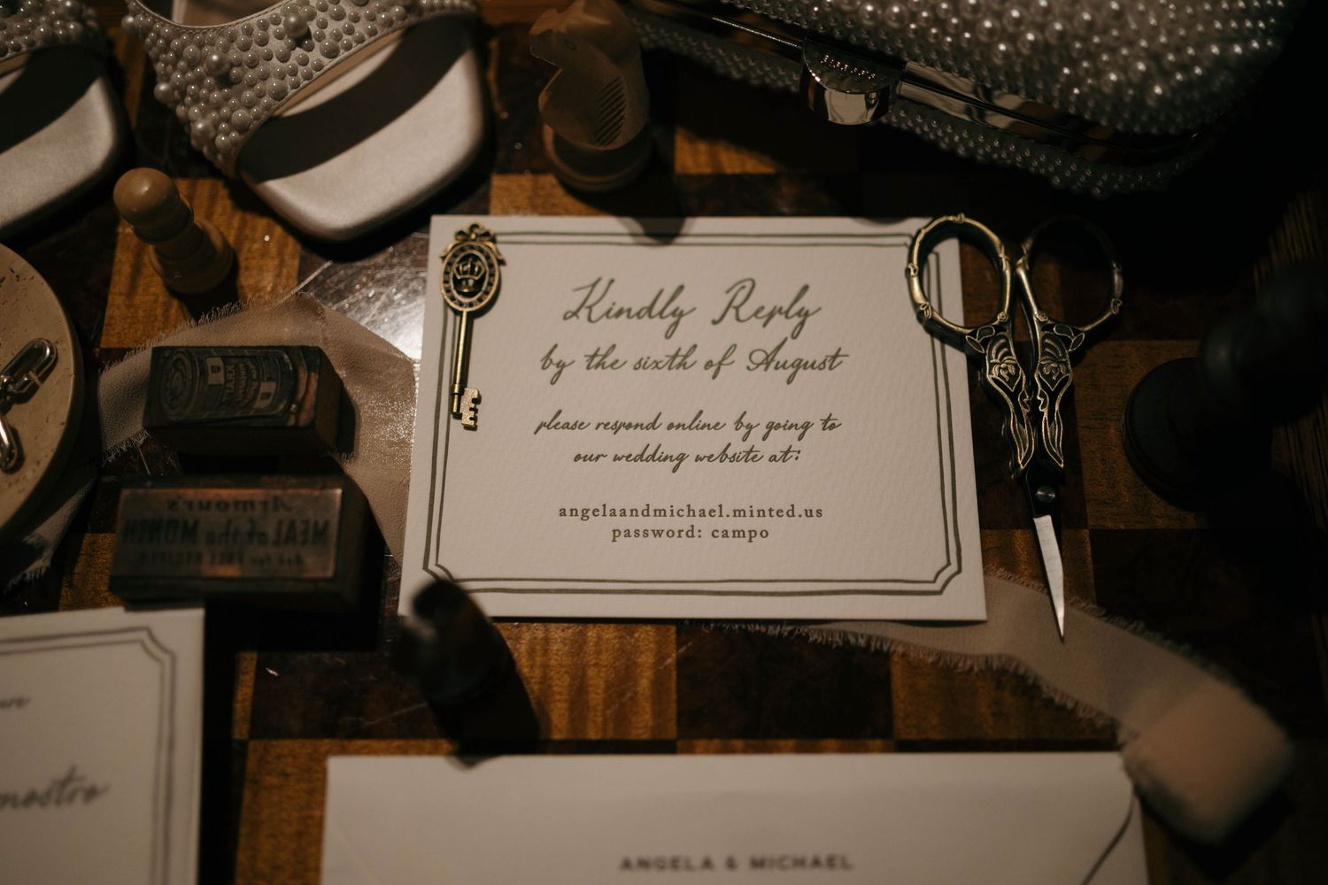 A vintage-style wedding invitation with decorative keys on a wooden surface.