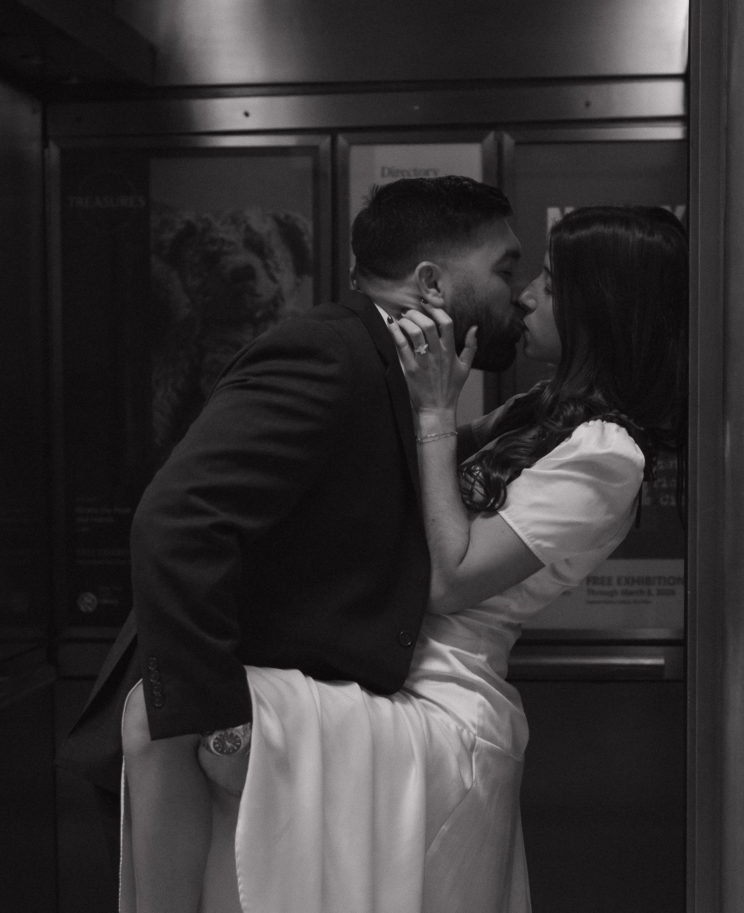 A couple embraces in a dark corridor with dramatic lighting.