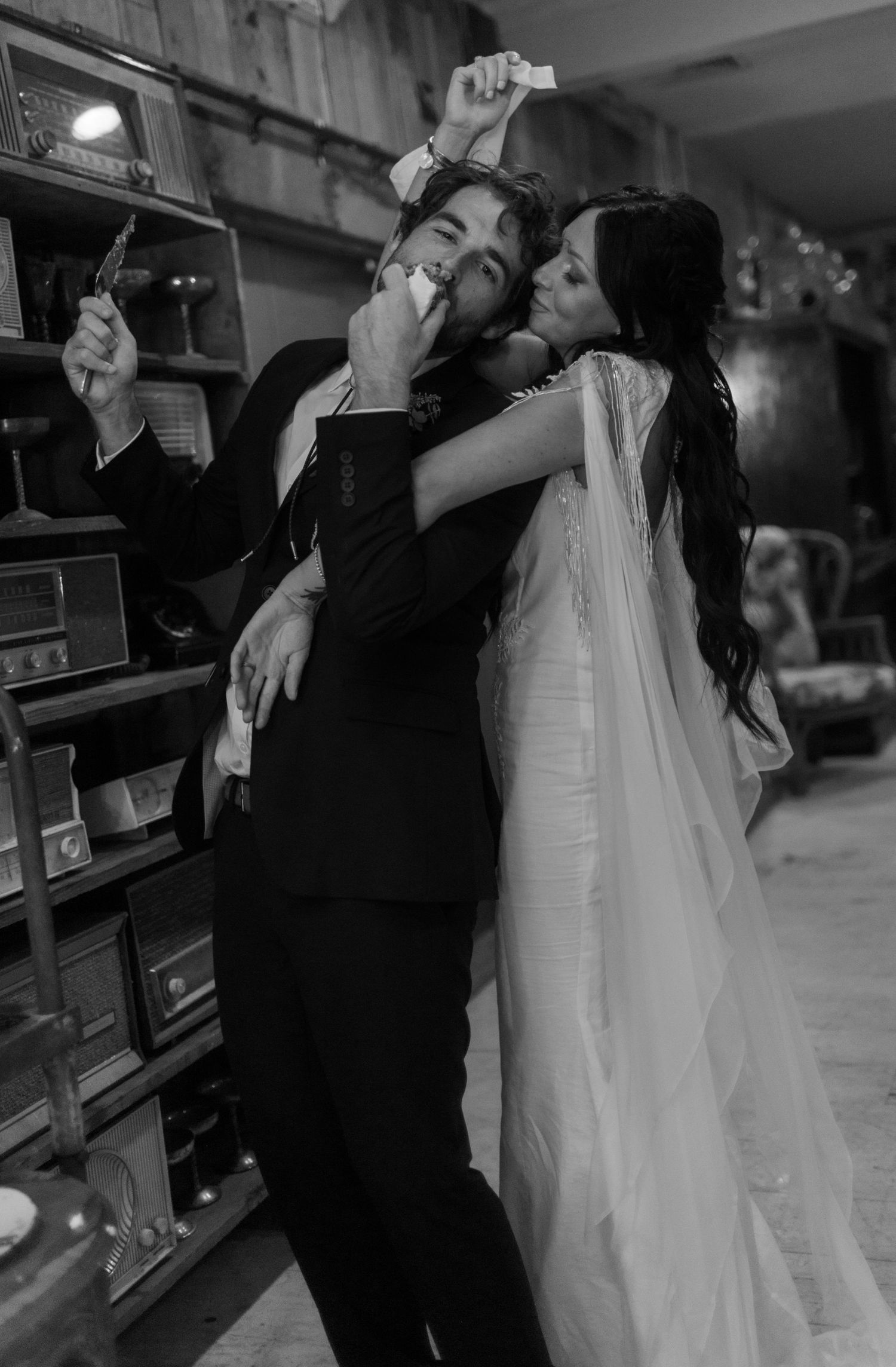 Black and white photo series of newlyweds taking shots at a their wedding cake.