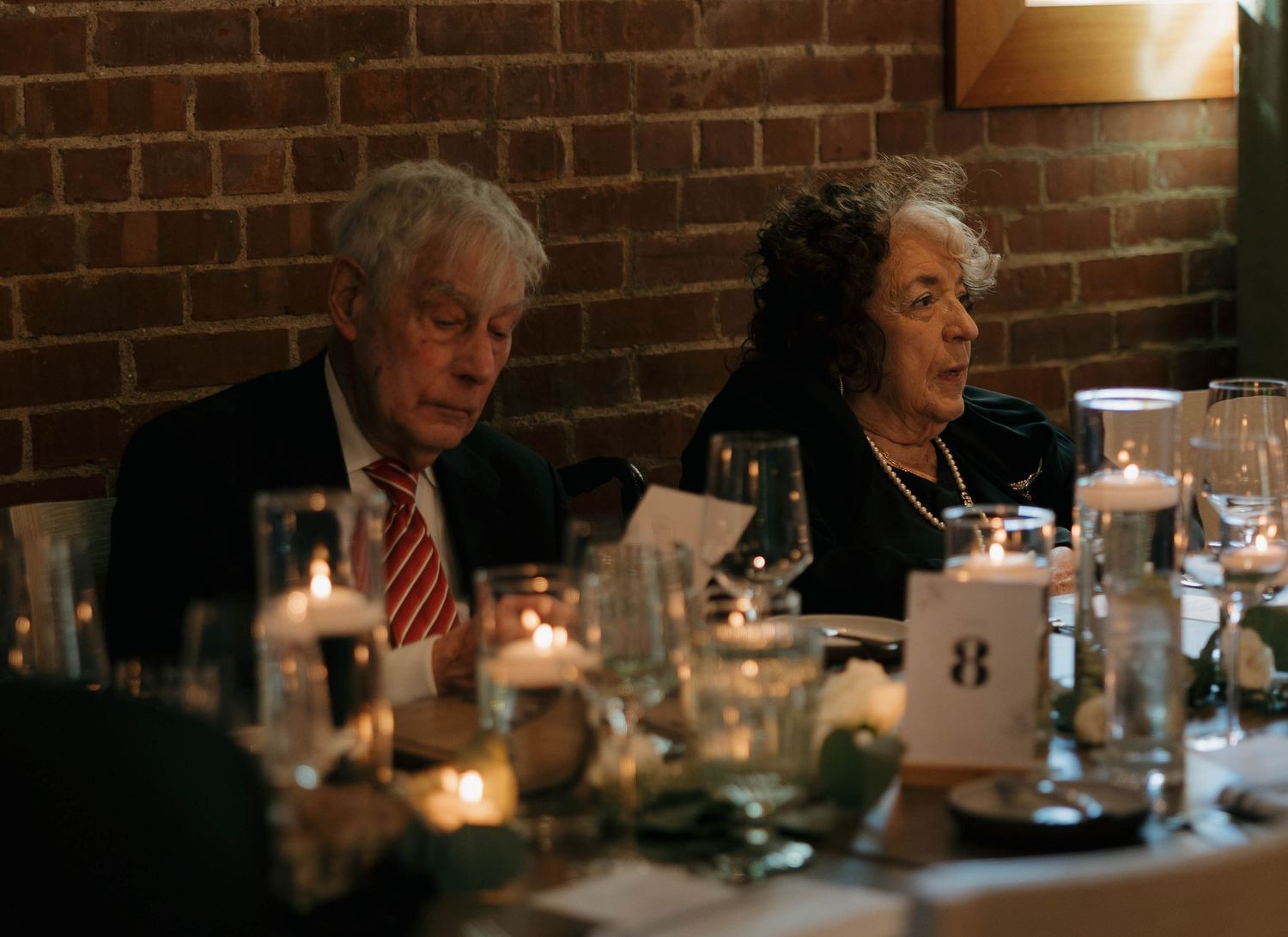 Guests enjoy an intimate candlelit dinner reception at elegant table setting.