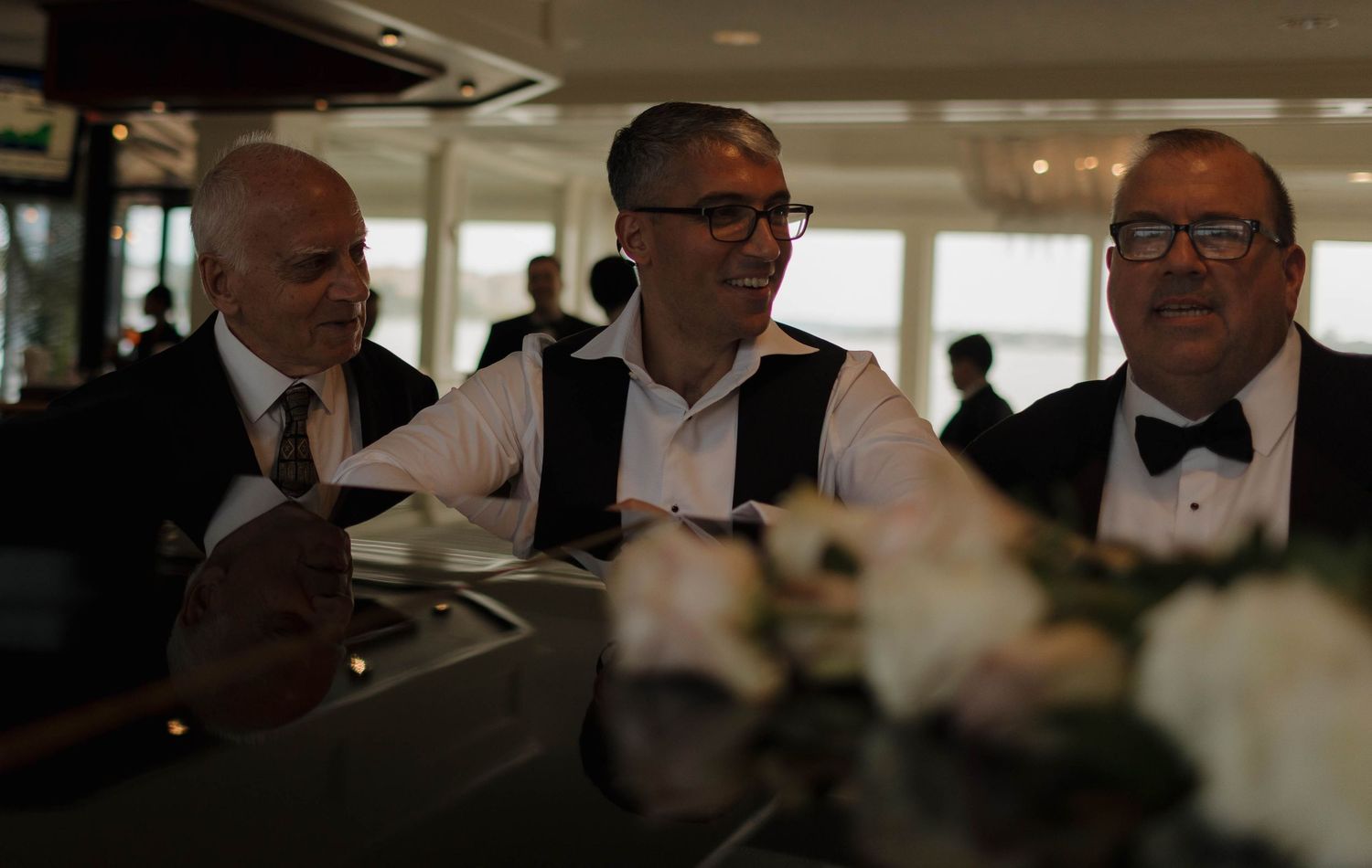 Formal event guests seated in elegant attire at a dimly lit venue.