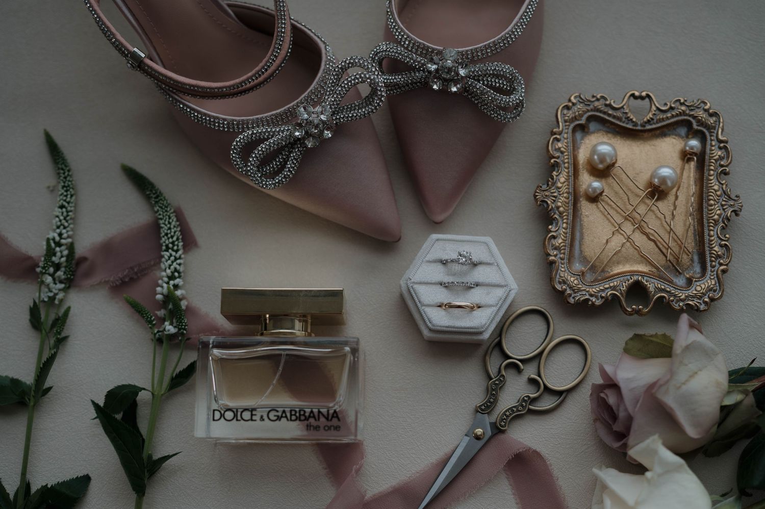 Wedding accessories including perfume, shoes, and decorative items arranged in flat lay style.