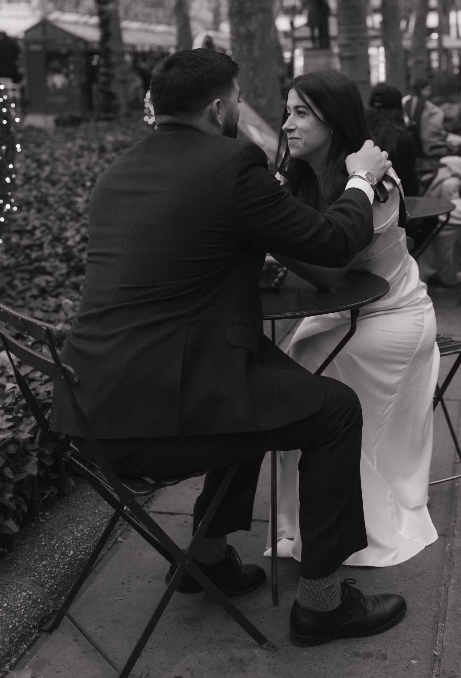 A couple sitting on folding chairs in an outdoor urban setting.
