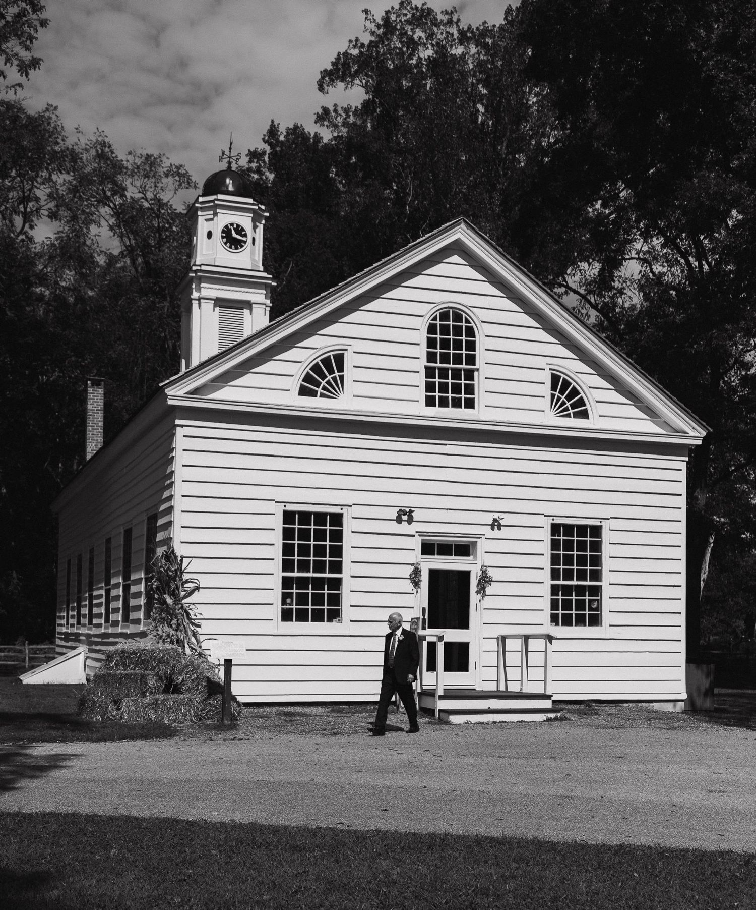 Classic white church building with multiple windows photographed in black and white.
