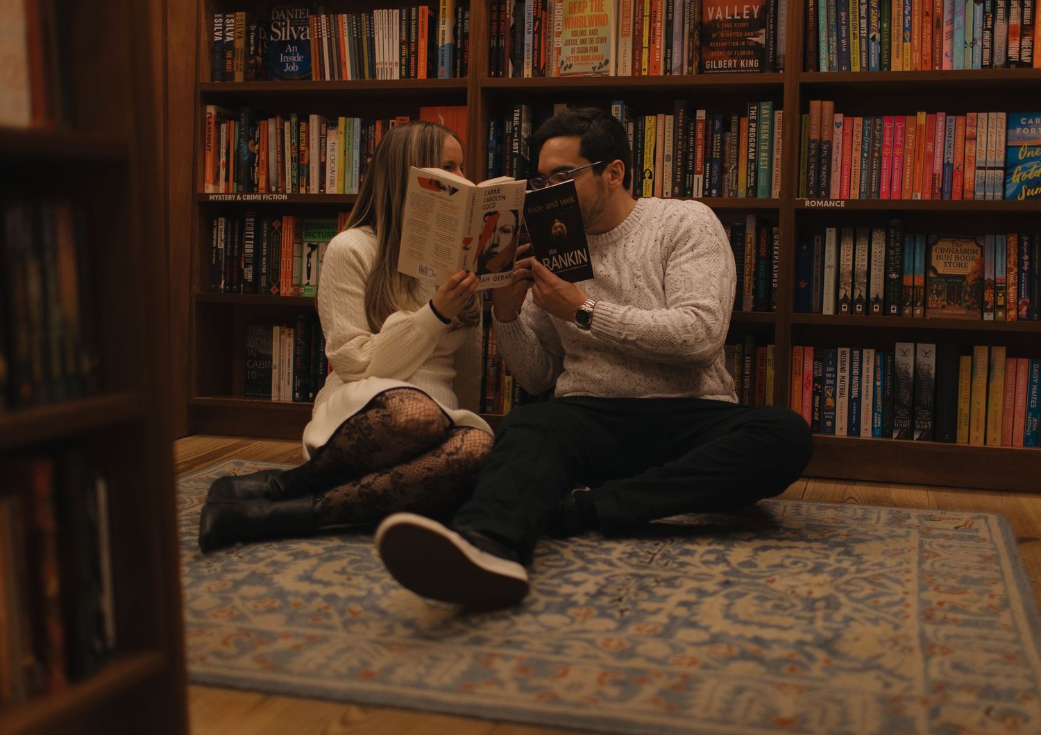 Cozy reading scene in library with bookshelves creating warm atmosphere.