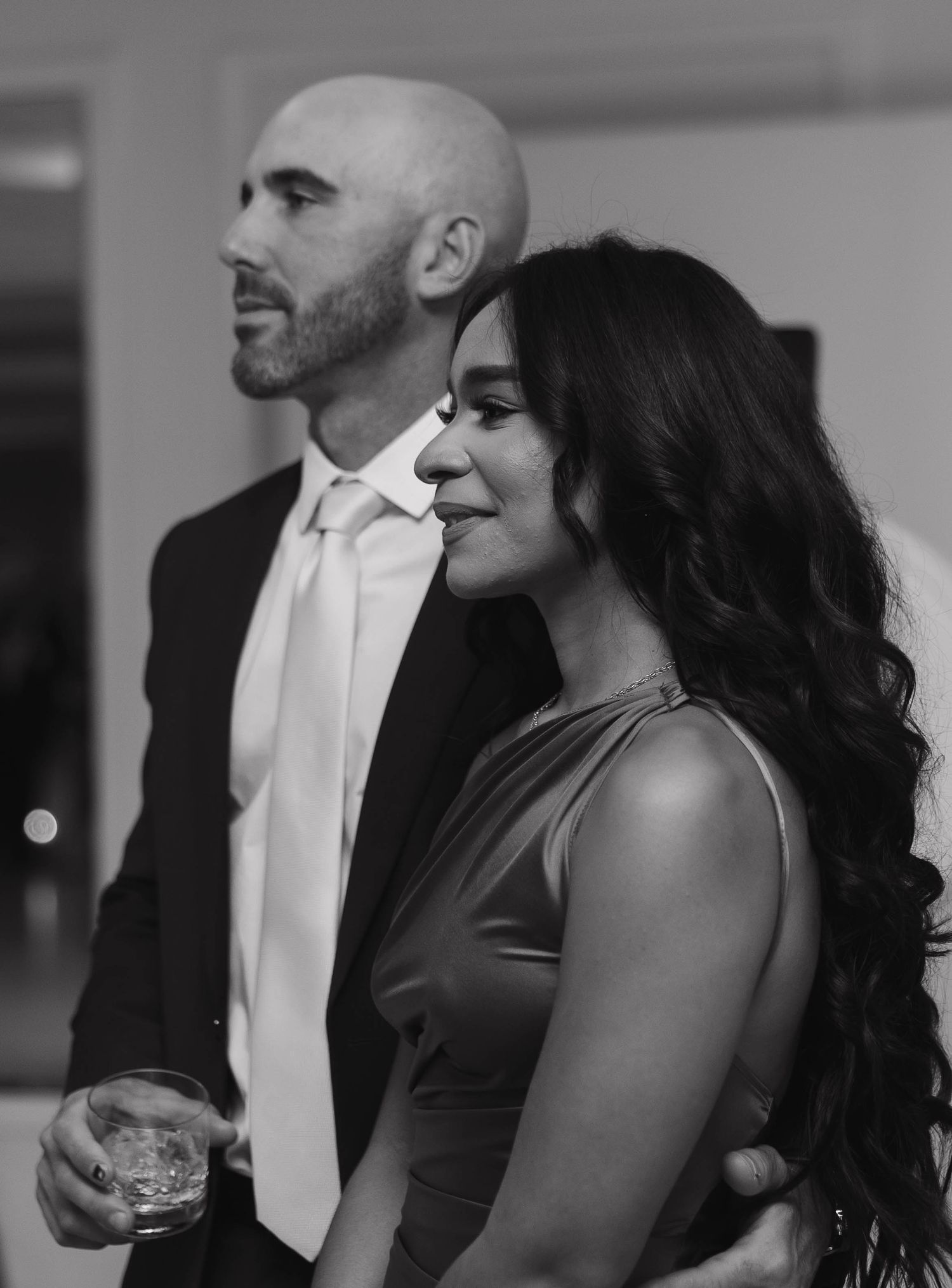 A couple shares an intimate moment at an elegant black-tie event.