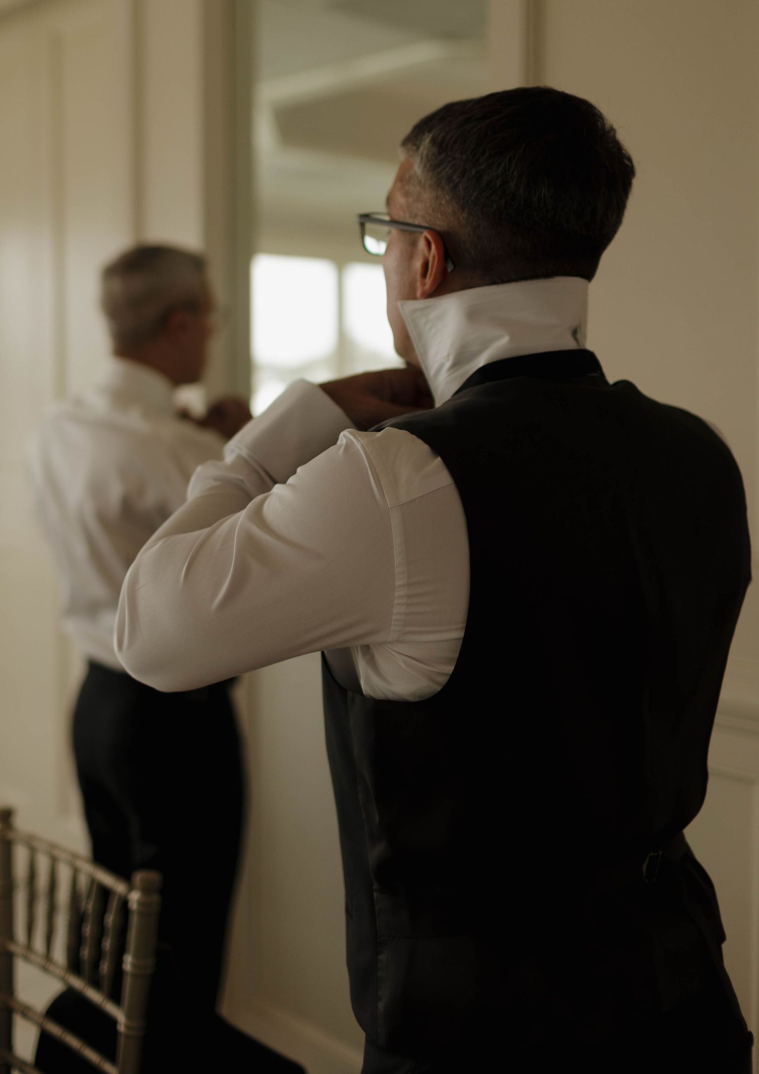Candid moment of formal event preparation in elegant venue hallway.