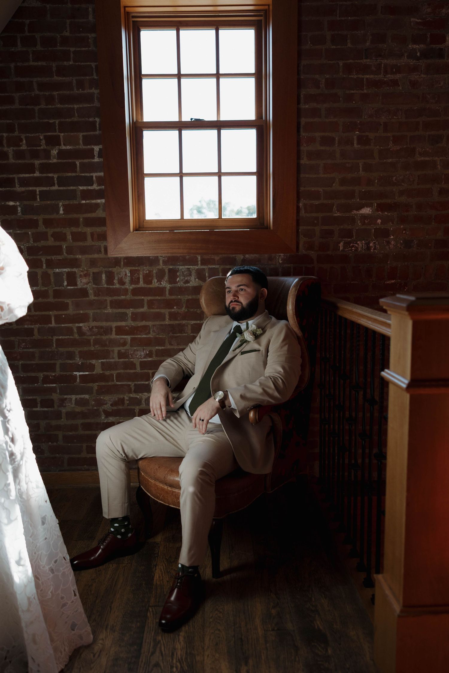 Interior scene of exposed brick walls and wooden floors with natural window lighting.