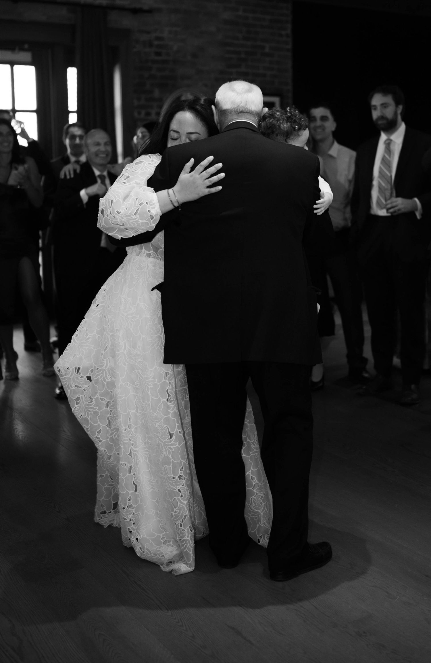 An emotional dance moment captured in black and white at an indoor wedding reception.