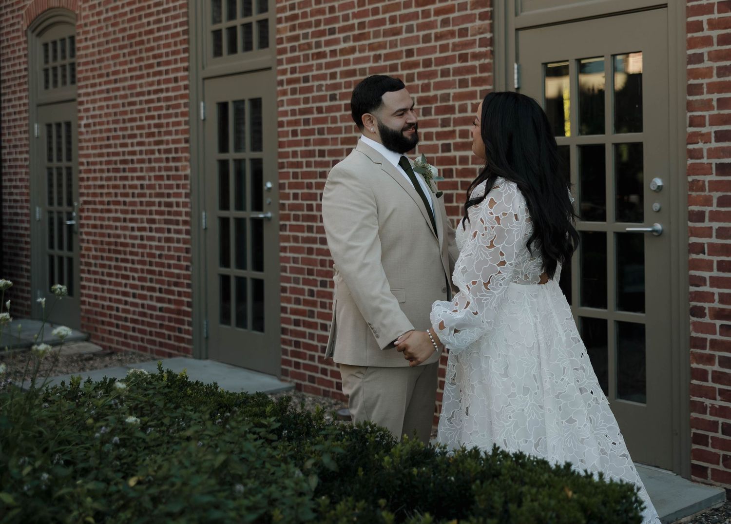 Wedding couple photographed against classic brick architecture.
