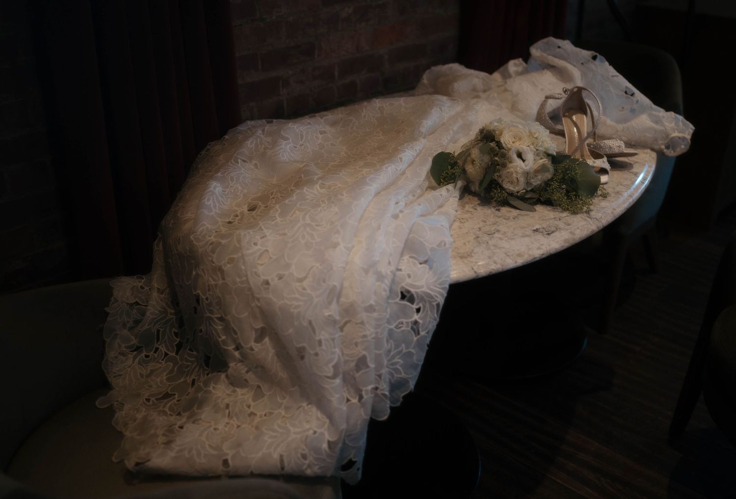 White lace wedding dress detail shot in dramatic lighting.