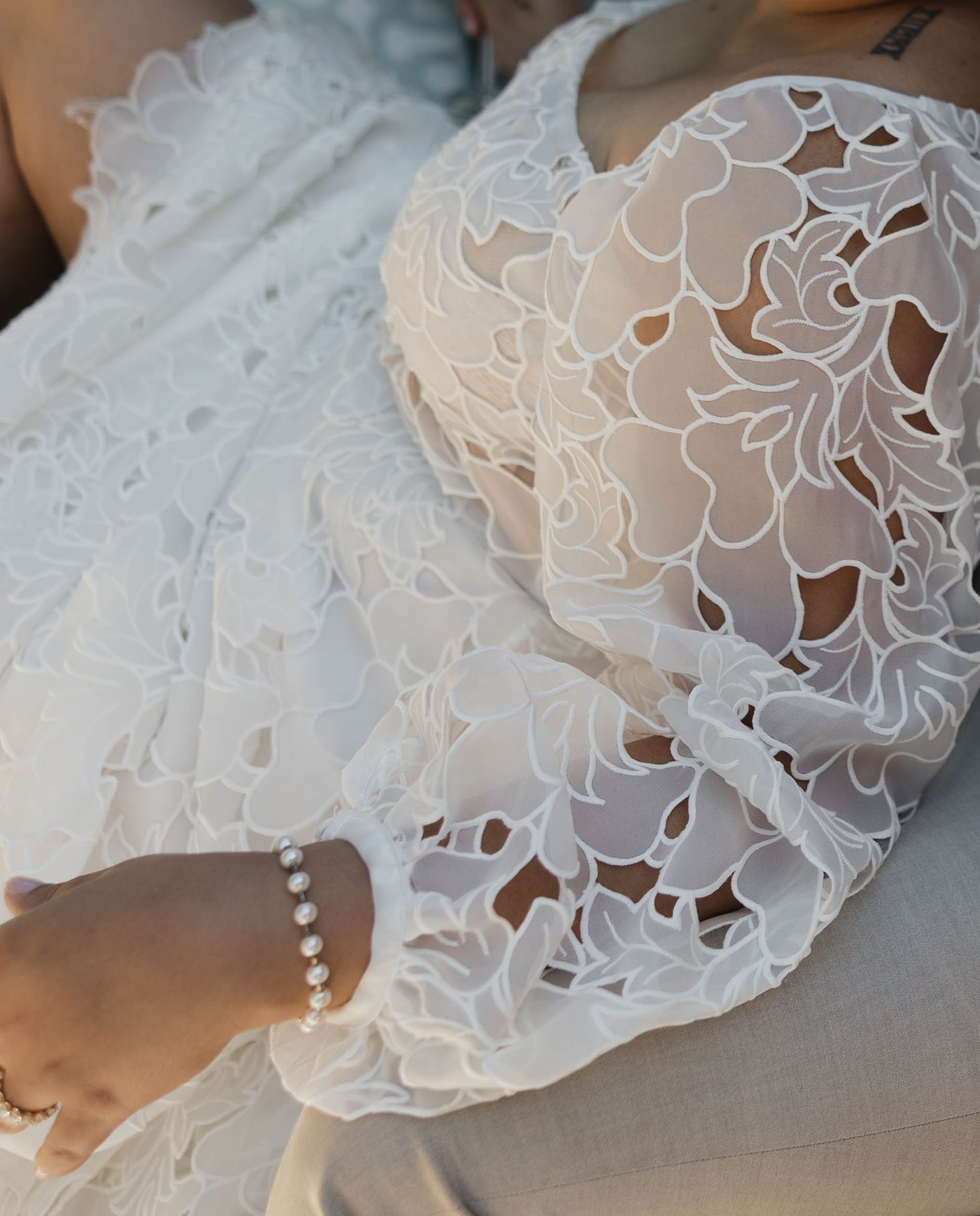 Intricate lace detail of white wedding dress with delicate button closures.