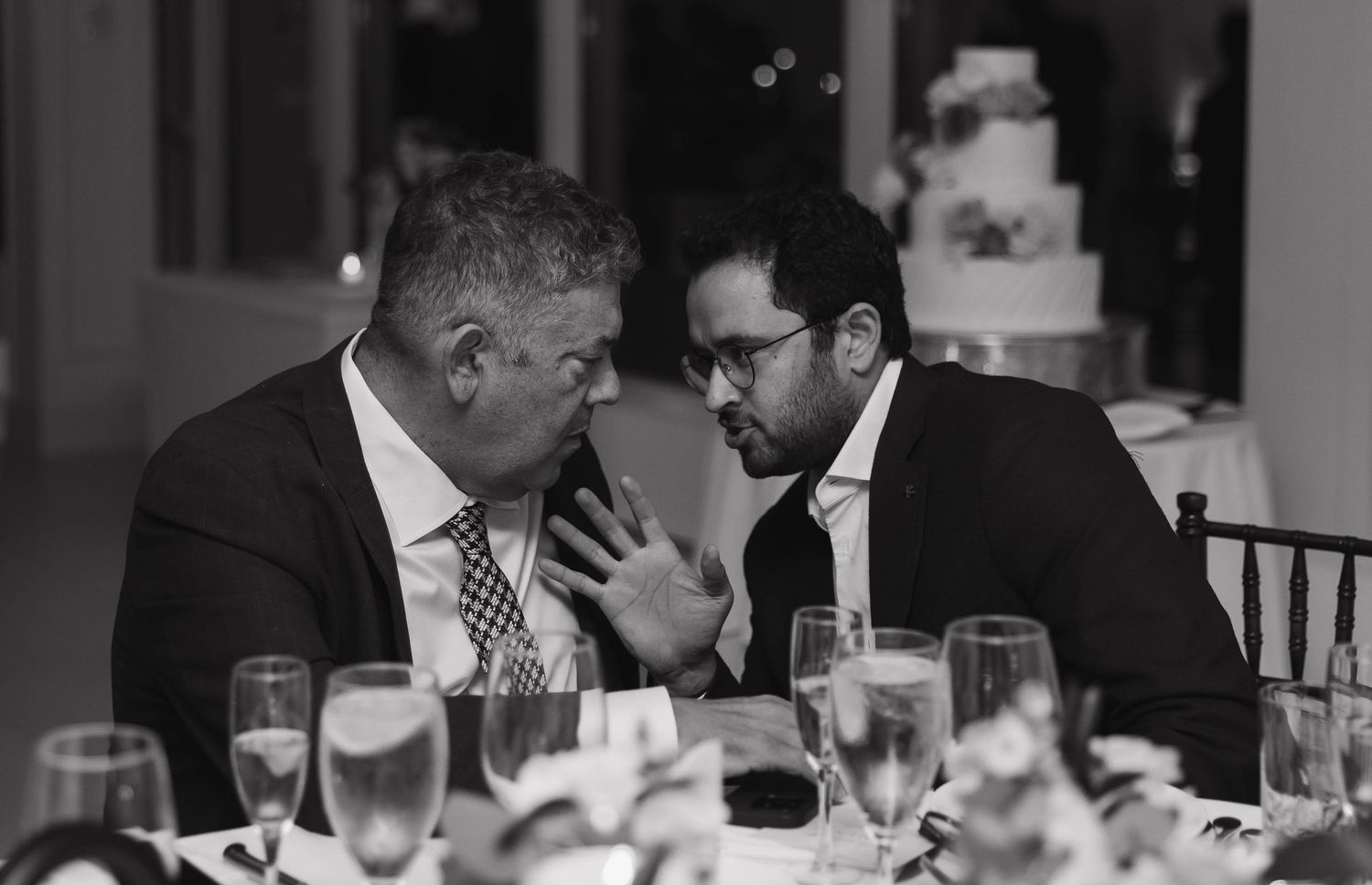 Wedding guests enjoying conversation at a formal dinner reception.