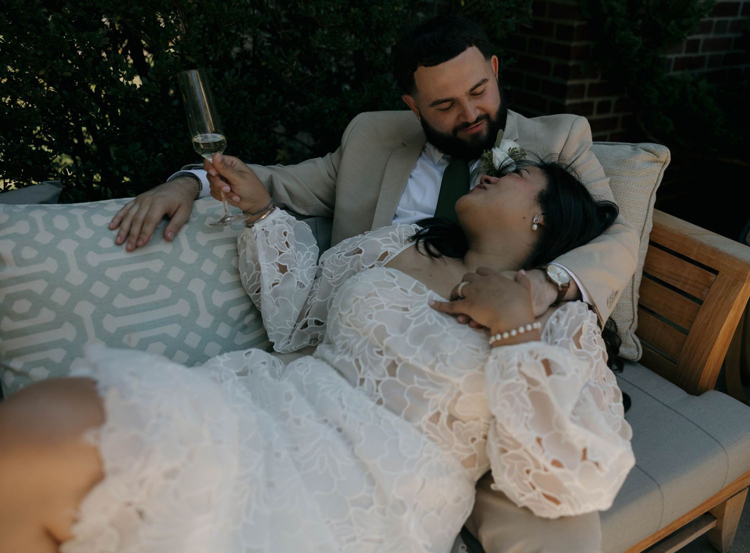 Couple relaxing together on plush indoor seating wearing formal attire.