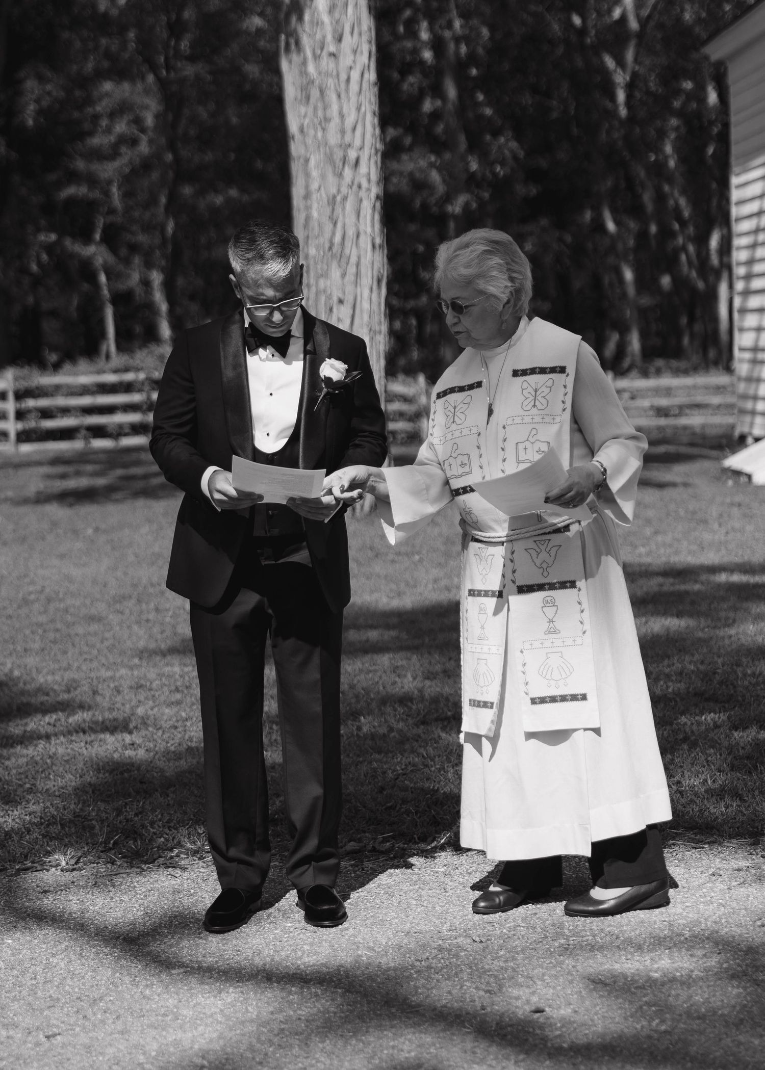 A vintage black and white photo of two people reviewing documents outdoors.