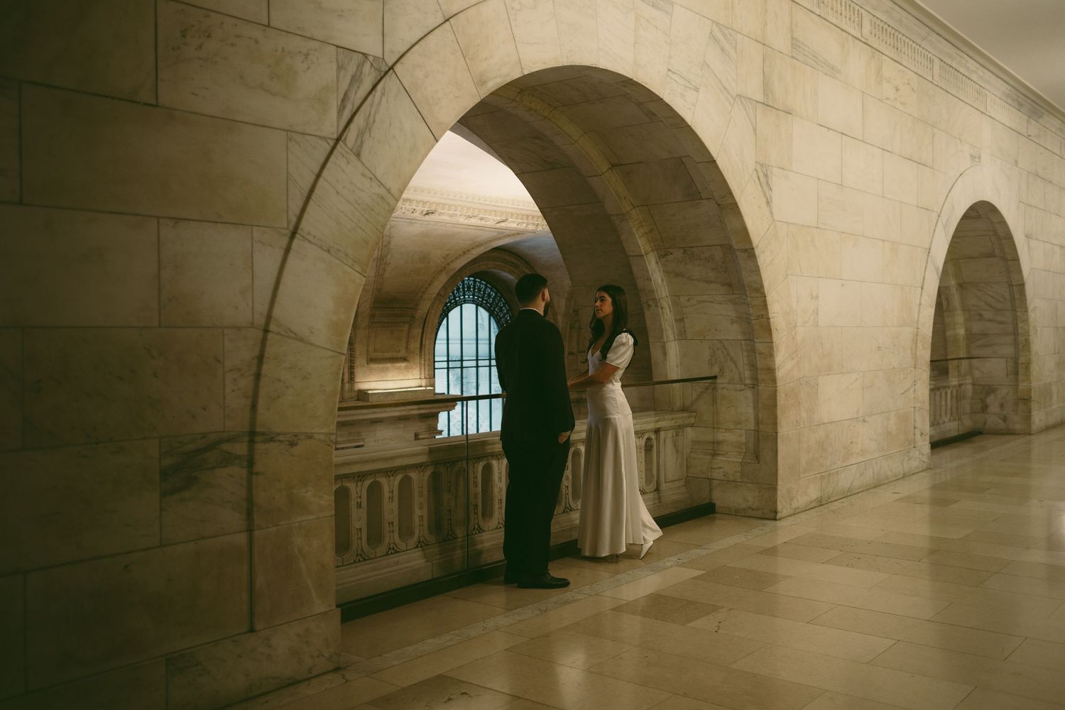 Long stone corridor with arched ceiling and natural lighting.
