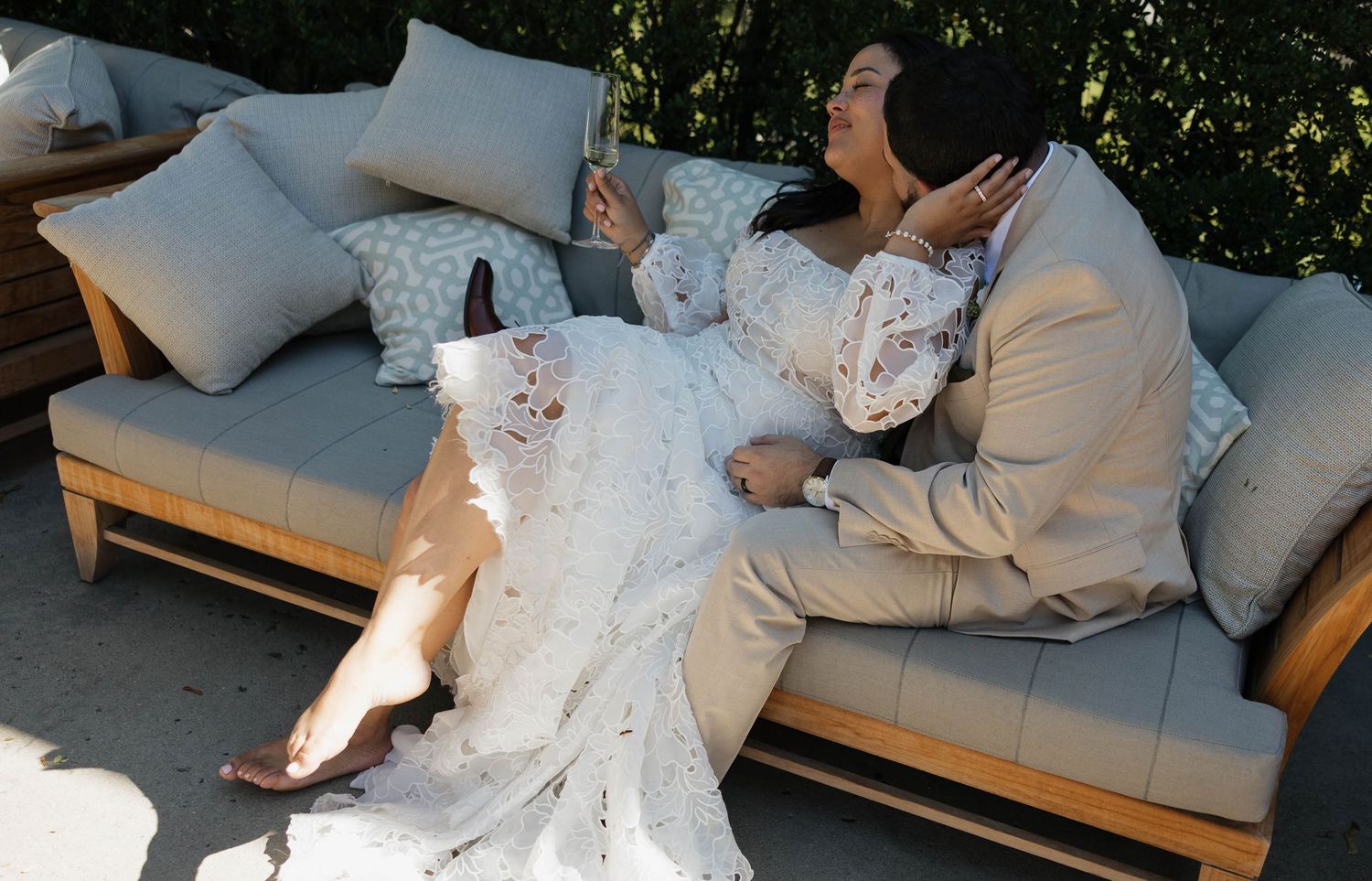 Wedding couple taking a relaxed moment together on modern outdoor lounge seating.