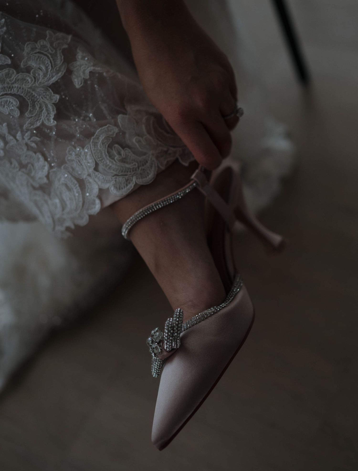 Close-up of delicate lace details and embellishments on a wedding shoe.