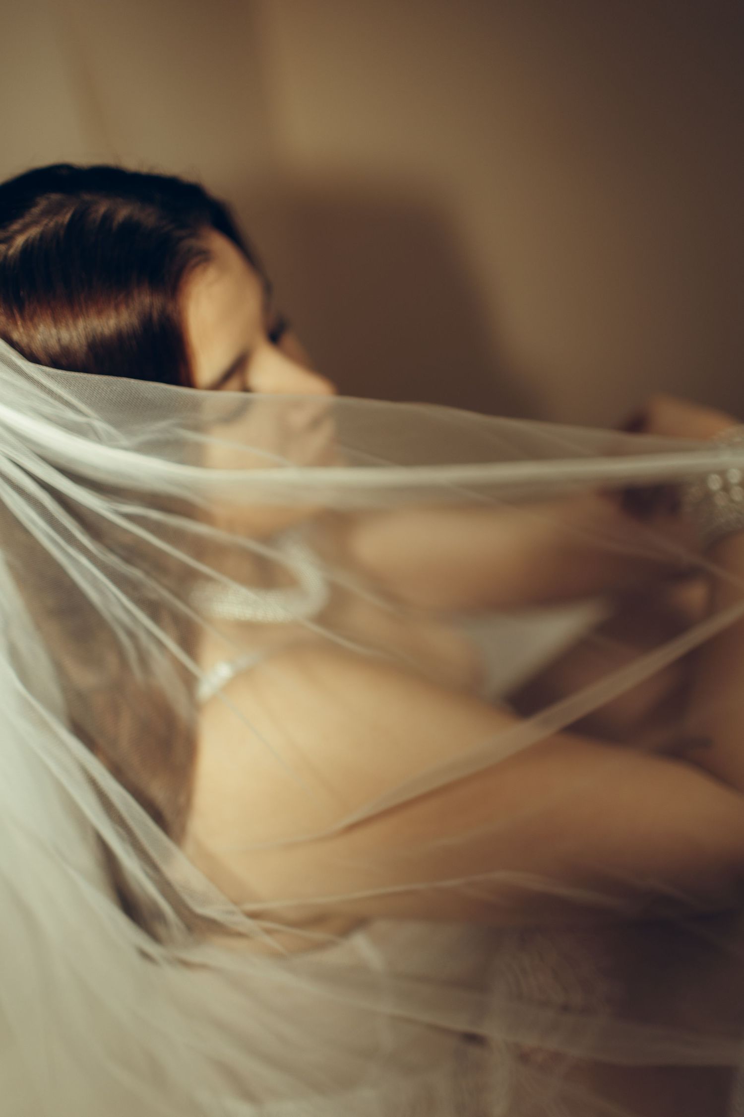 A series of abstract photographs showing white sheer fabric flowing and creating ethereal shapes against a dark background.