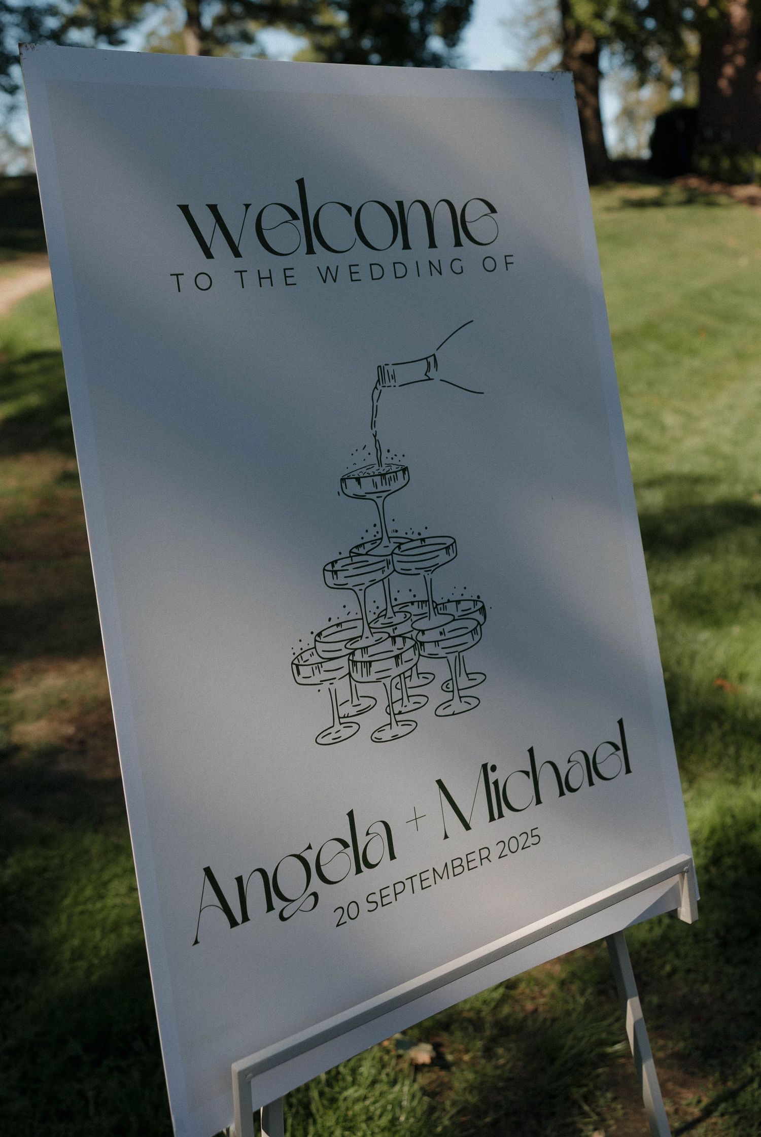 Wedding welcome sign with cupcake illustration displayed on white board.