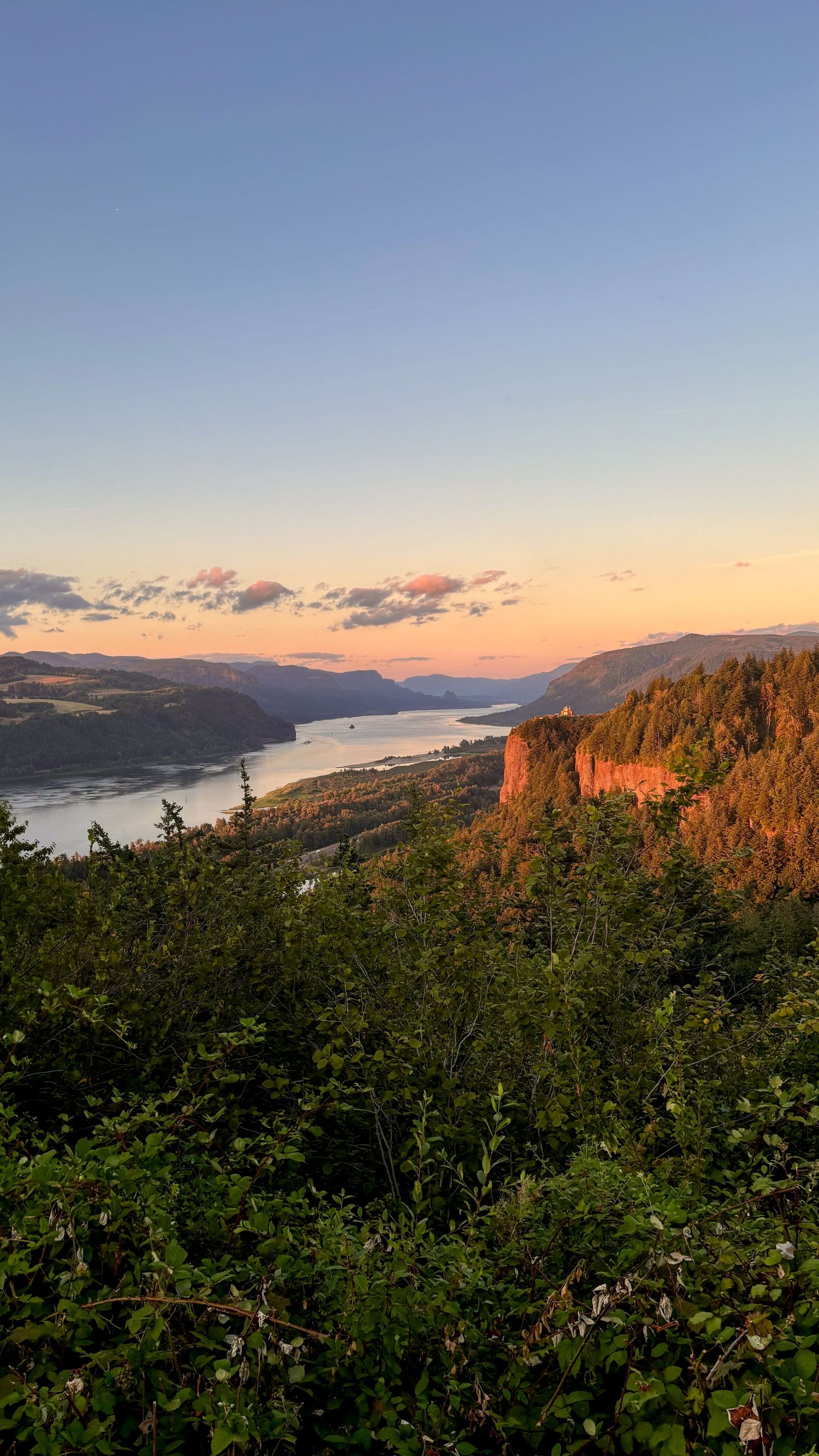 Columbia River Gorge landscape at sunset, with dramatic cliffs and warm evening light over the river
