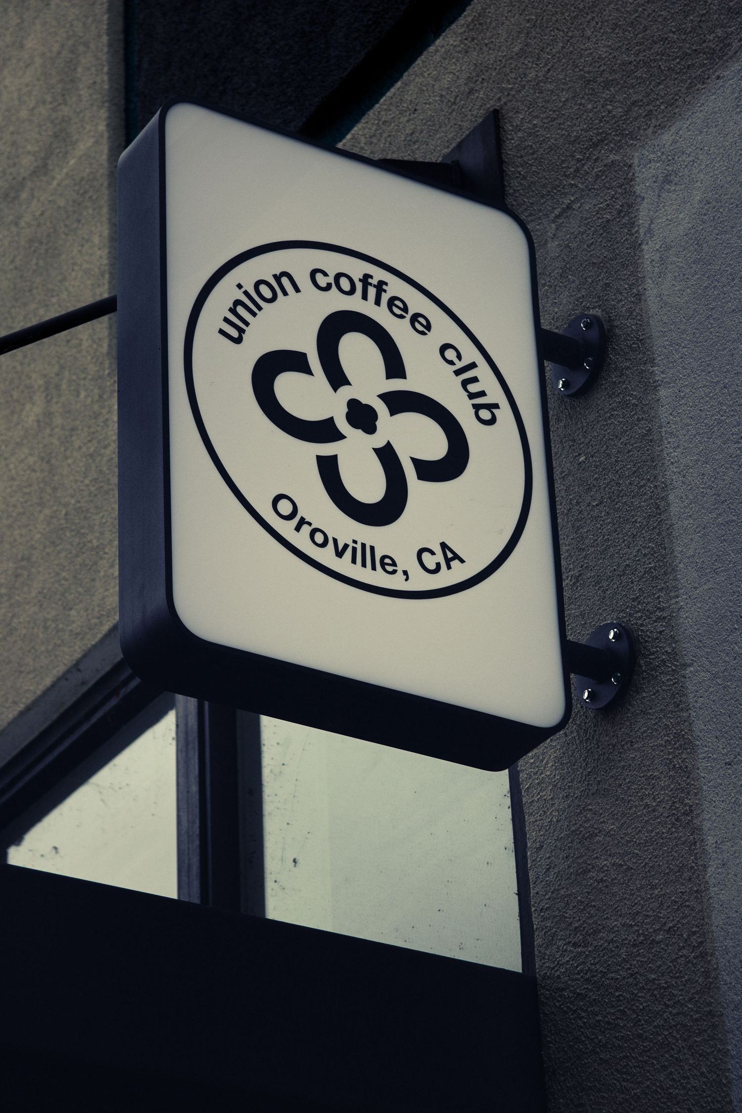 Black and white Union Coffee Club logo signs mounted on exterior wall.