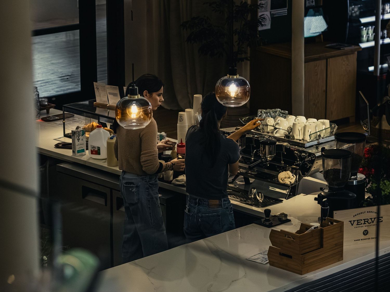 Coffee shop workspace with industrial lighting and minimalist design elements.