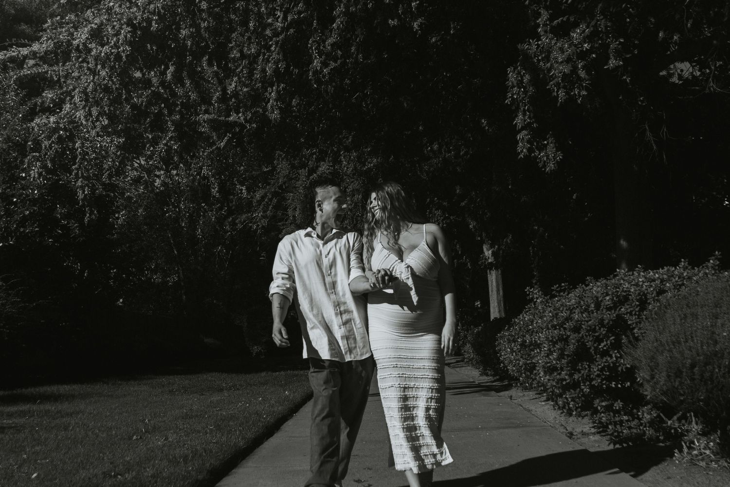 A couple walking together on a pathway in black and white photography.