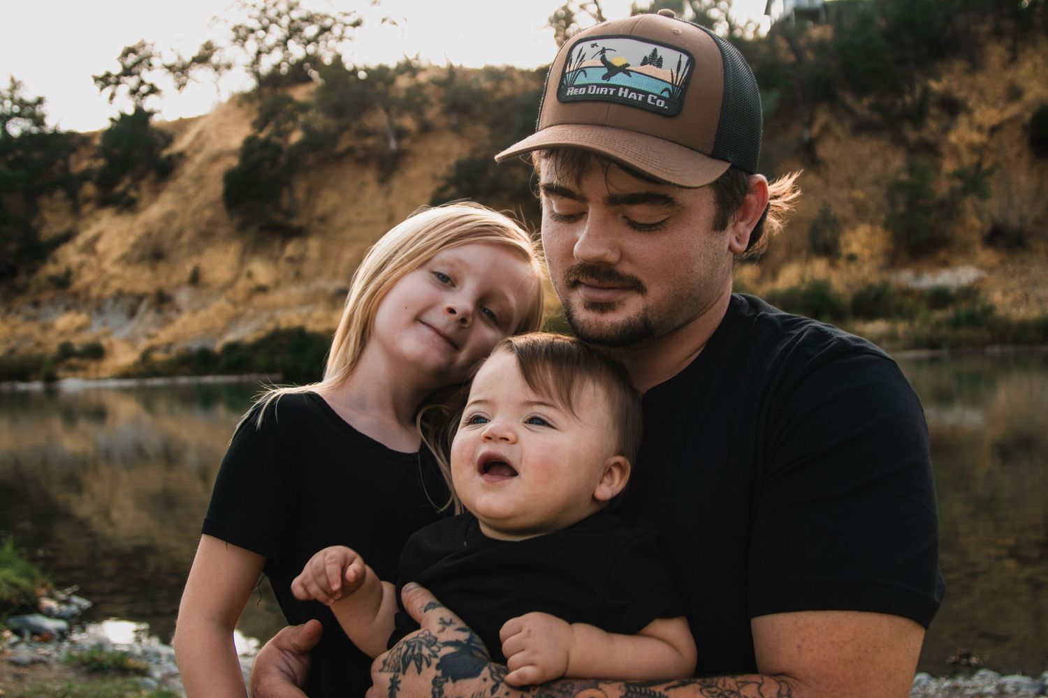 Family enjoying outdoor moments together near a body of water.