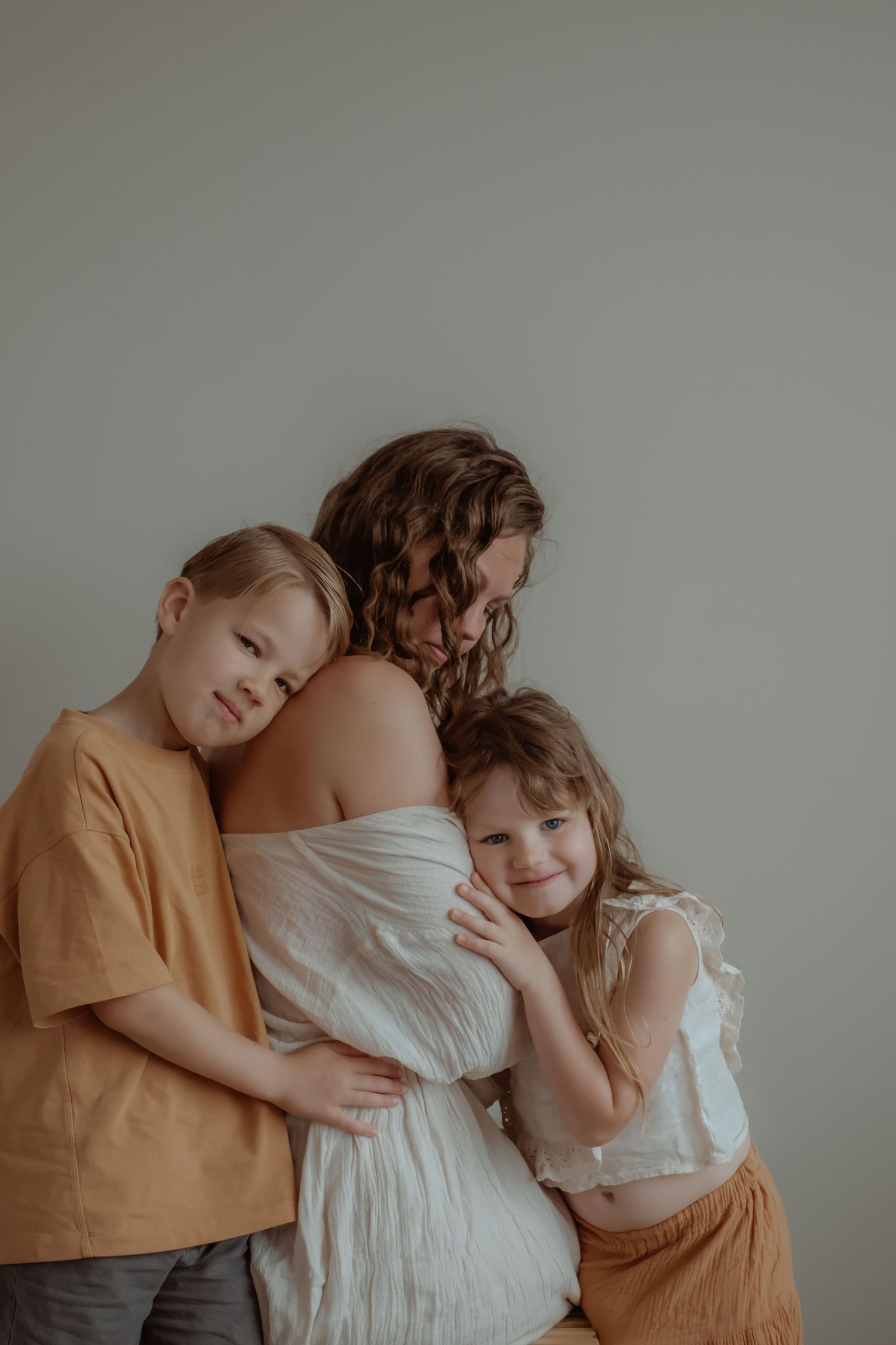 Moeder met haar twee kinderen tijdens een liefdevolle motherhood fotoshoot