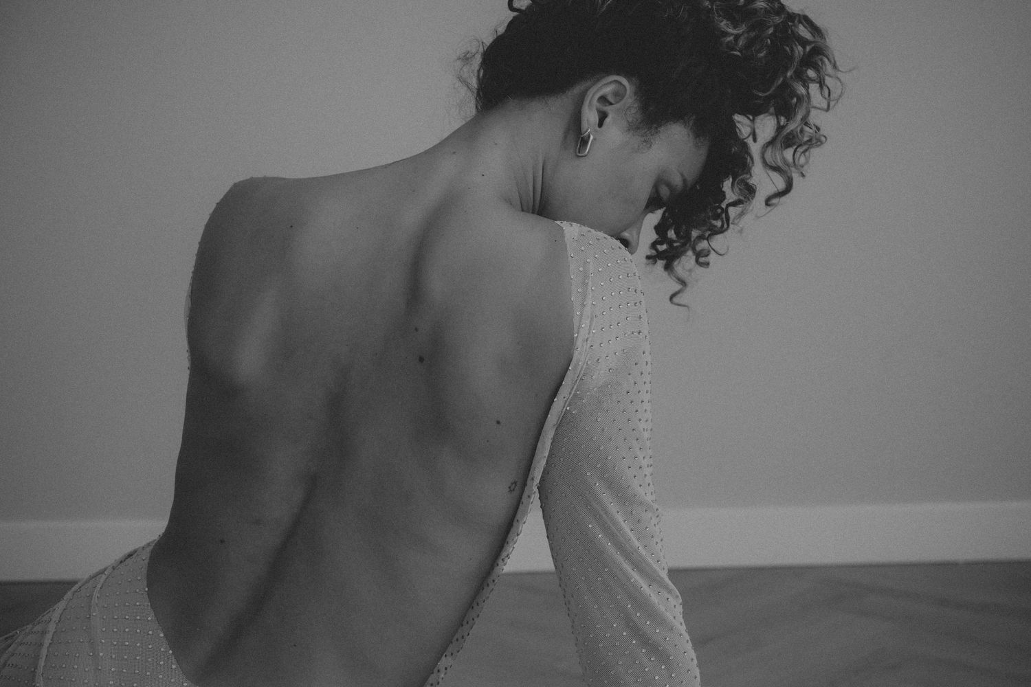 Vrouw met ontblote rug tijdens een intieme boudoir fotoshoot
