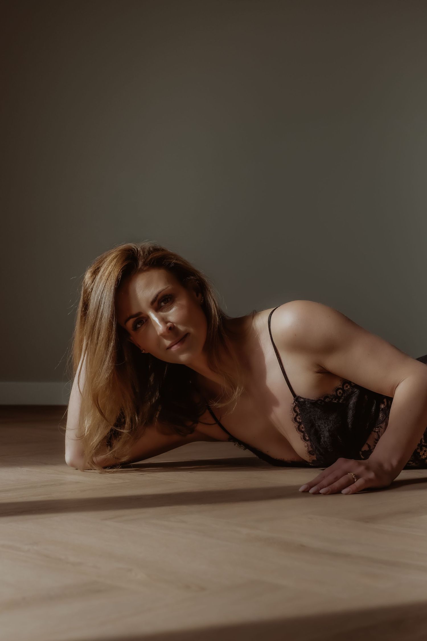 Vrouw liggend op de grond tijdens een sfeervolle boudoir fotoshoot