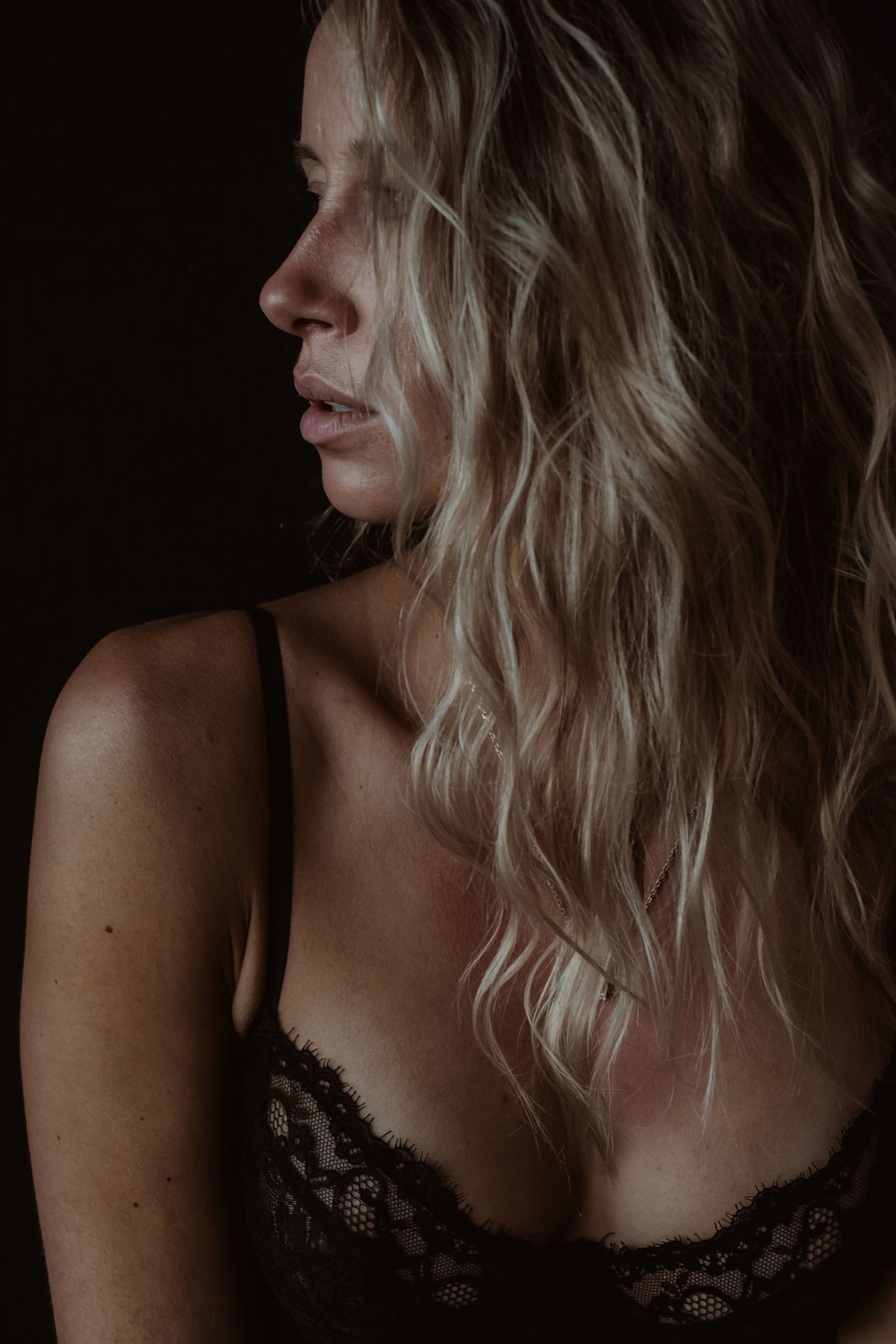 Close-up portret van een vrouw tijdens een sfeervolle boudoir fotoshoot