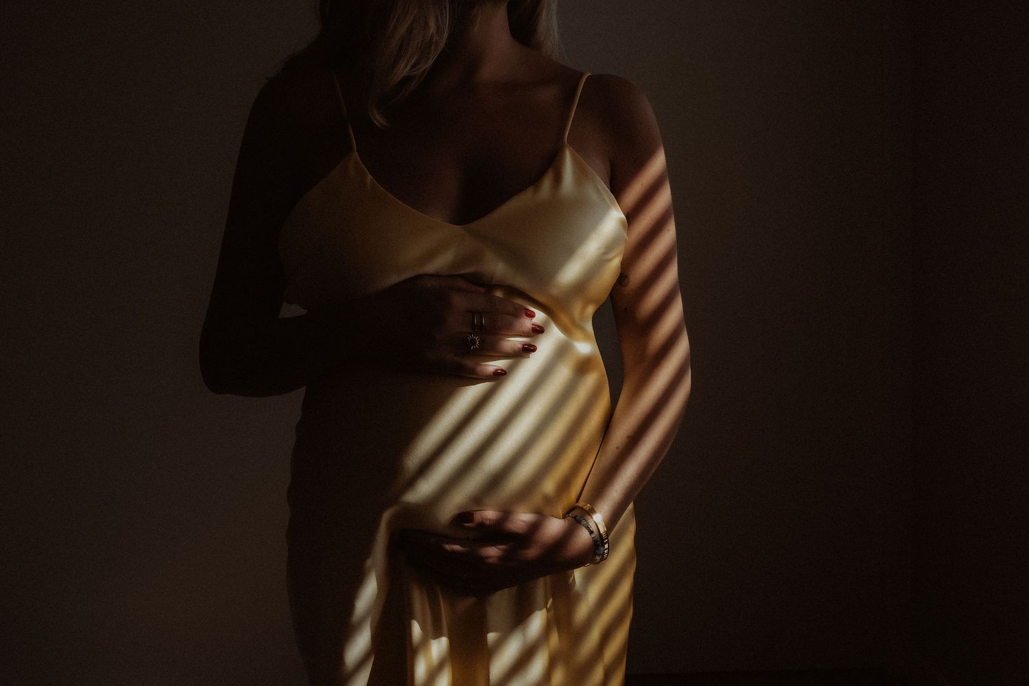 Zwangere vrouw in warm licht tijdens een zwangerschapsshoot
