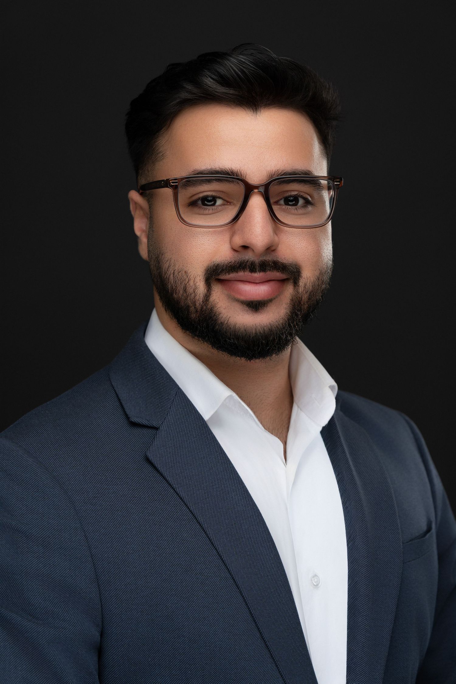 Professional male headshot with glasses, styled in a blue blazer and captured with soft directional lighting in Montreal.