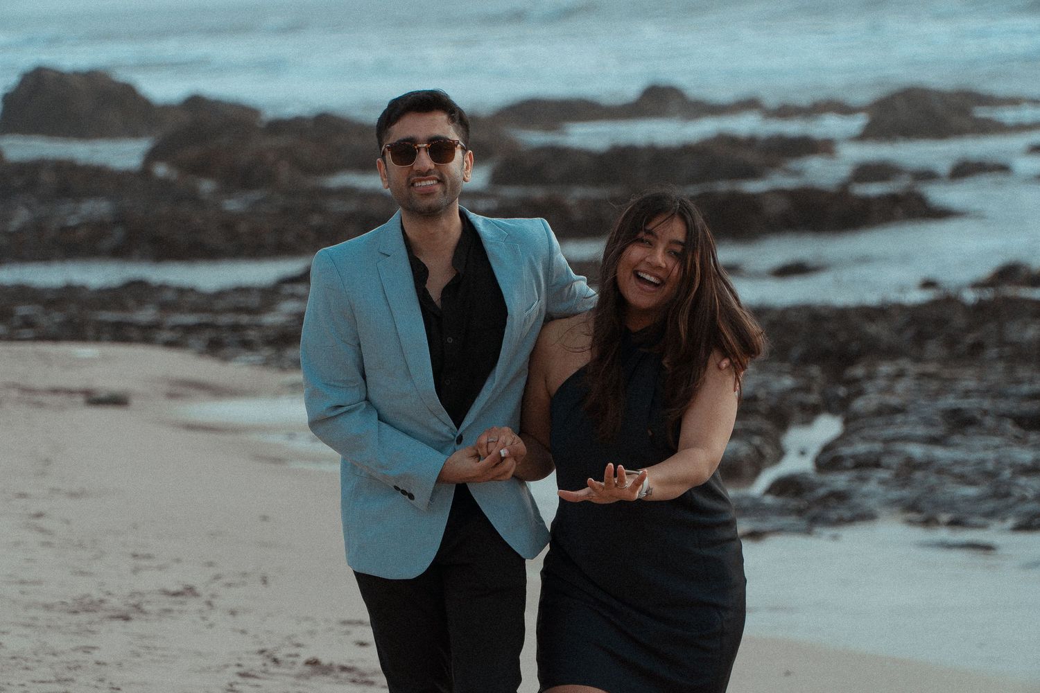 image capturing the moment of an engagement proposal between two people, framed by the timeless beauty of the California coastline