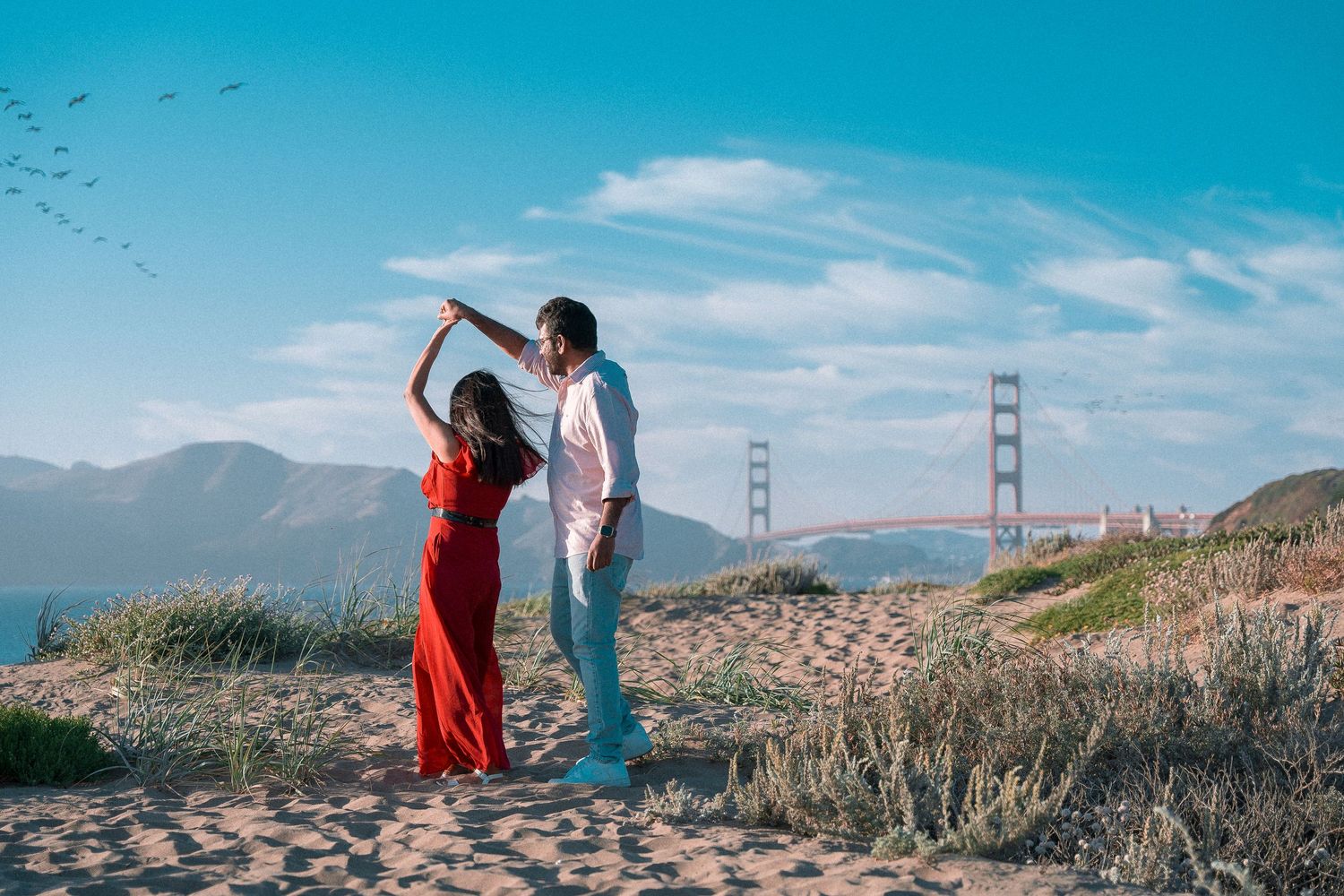 image capturing the moment of an engagement proposal between two people, framed by the timeless beauty of the Golden Gate Bridge