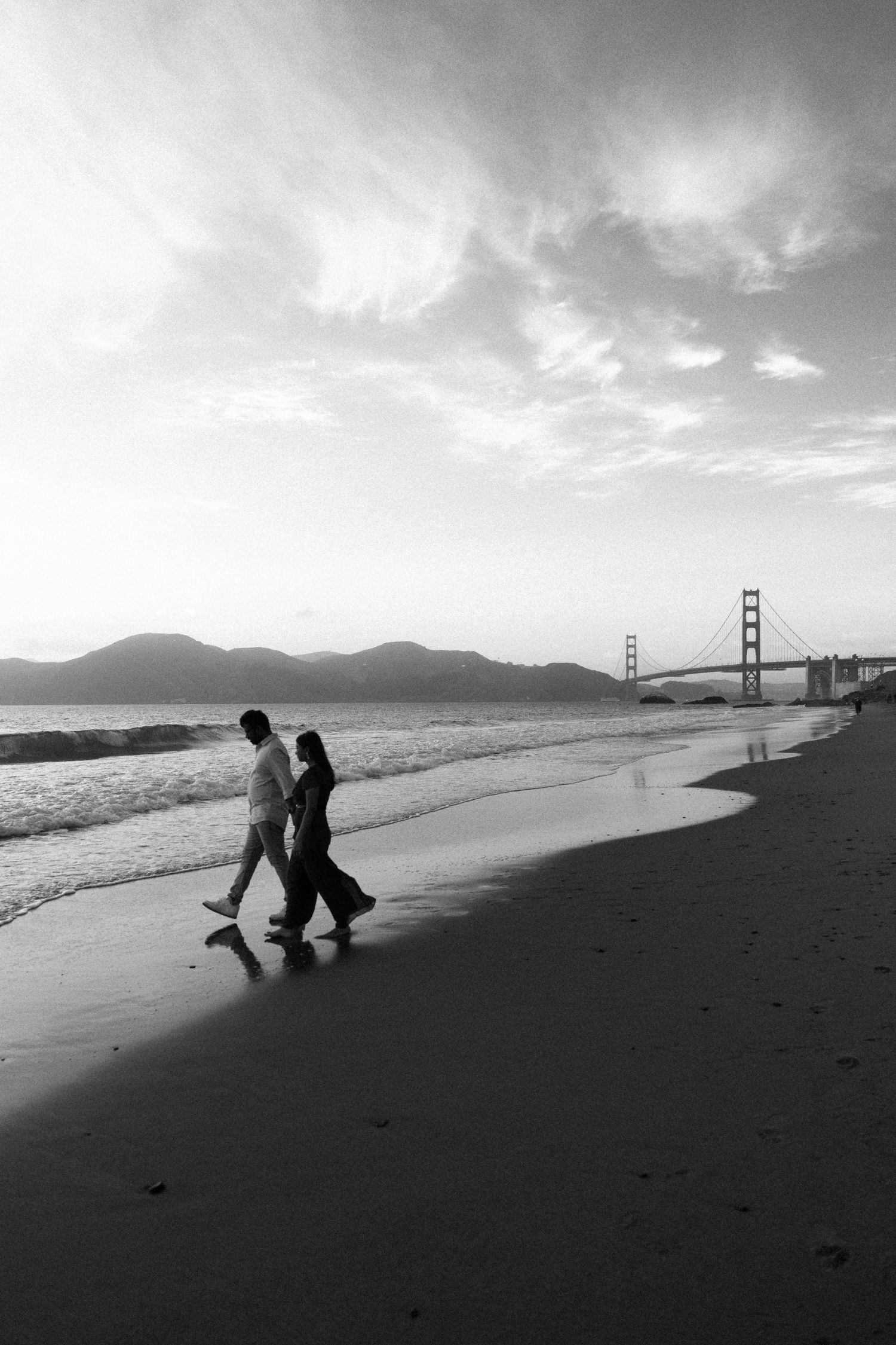 image capturing the moment of an engagement proposal between two people, framed by the timeless beauty of the California coastline