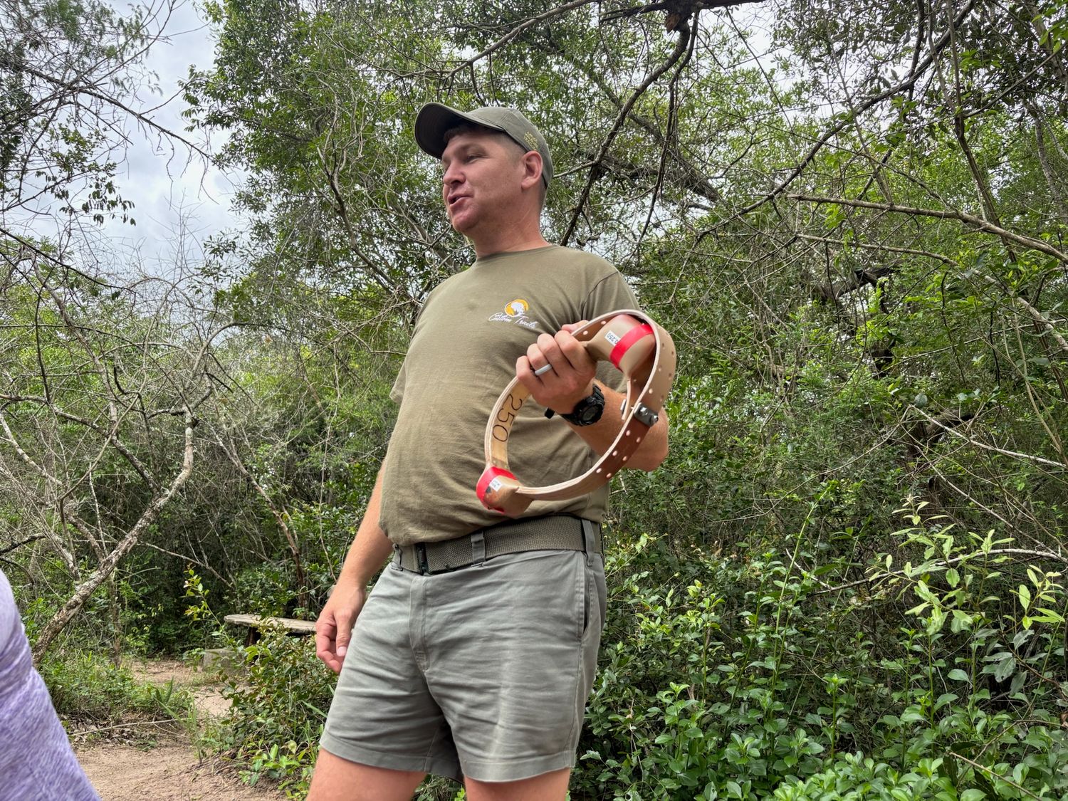 A person holding a wildlife tracking device or other equipment in a natural outdoor environment.