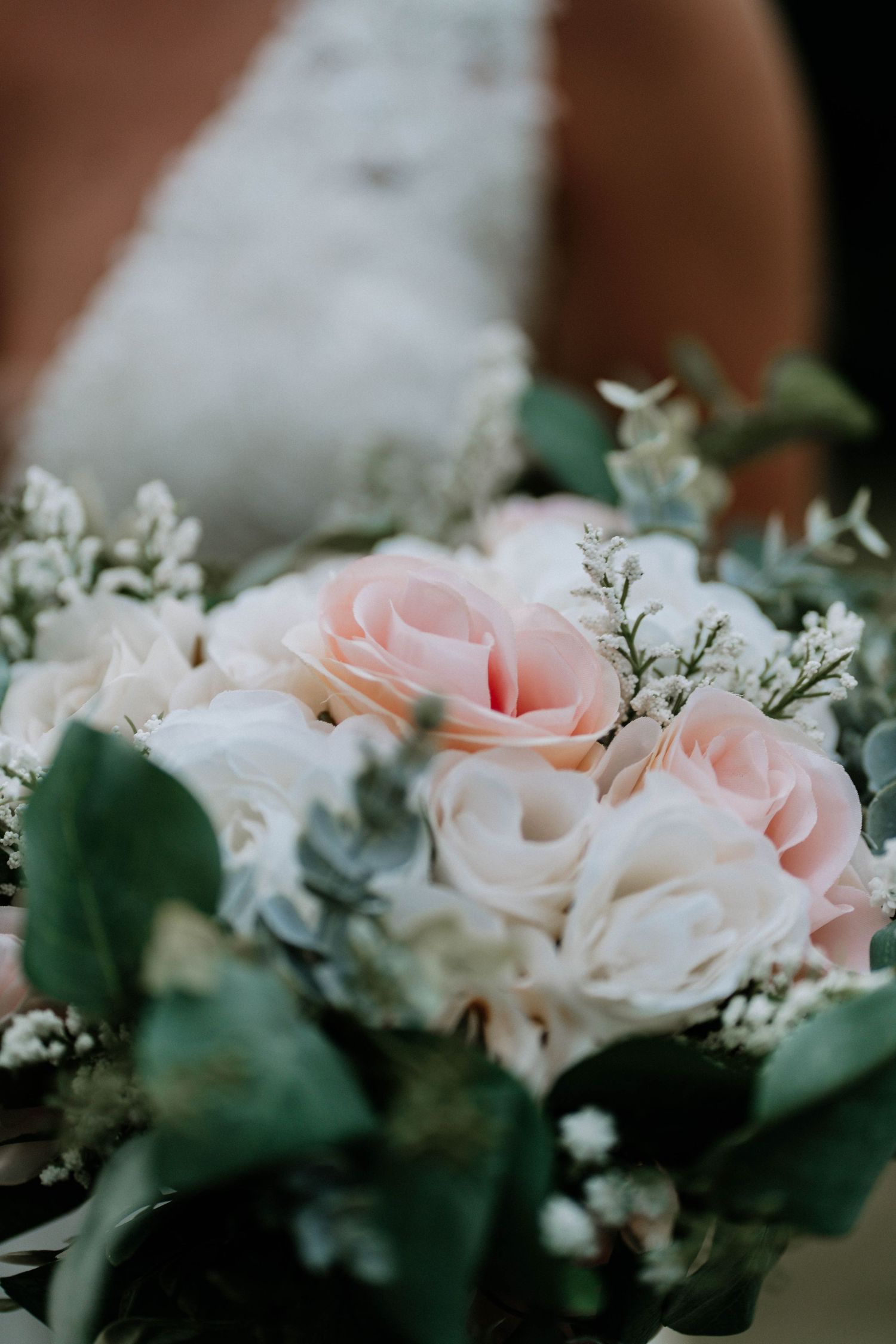Elegant bridal bouquet featuring soft pink roses, white flowers, and greenery.