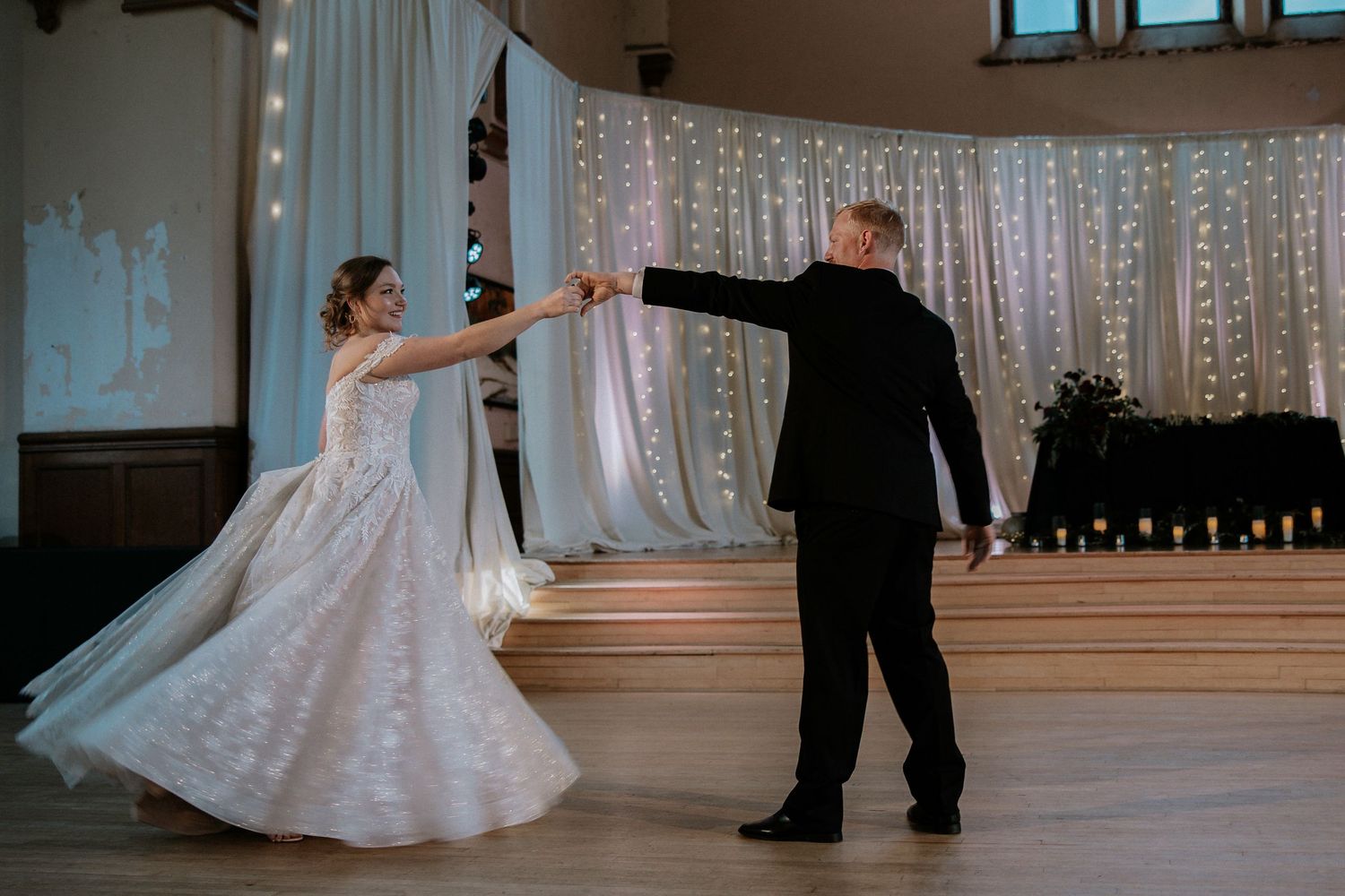 Bride and groom share their first dance in an elegant wedding venue adorned with fairy lights at Urban Artifact in Cincinnati, Ohio