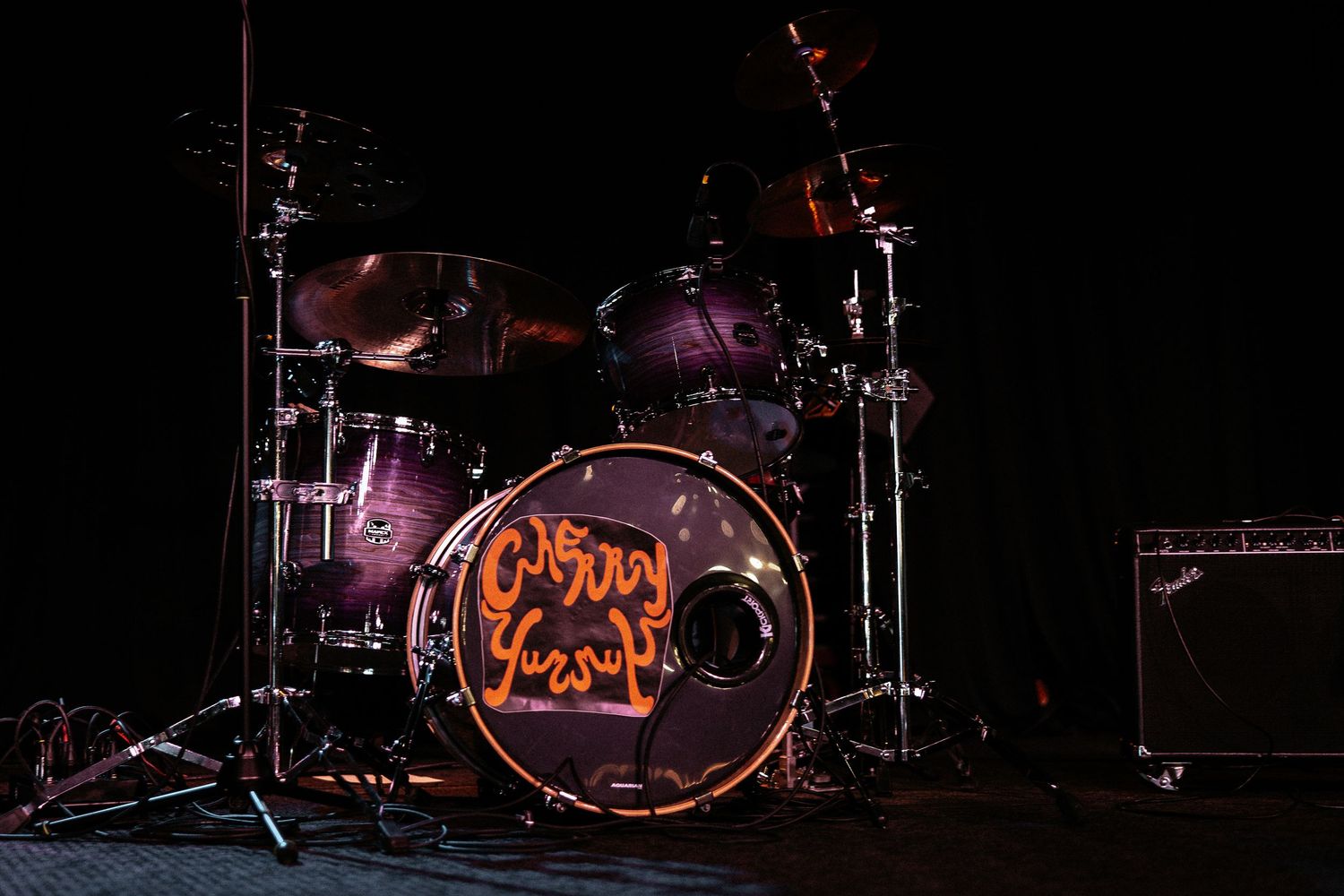 Cherry Purcup band drum kit with illuminated logo on stage at a wedding reception venue.