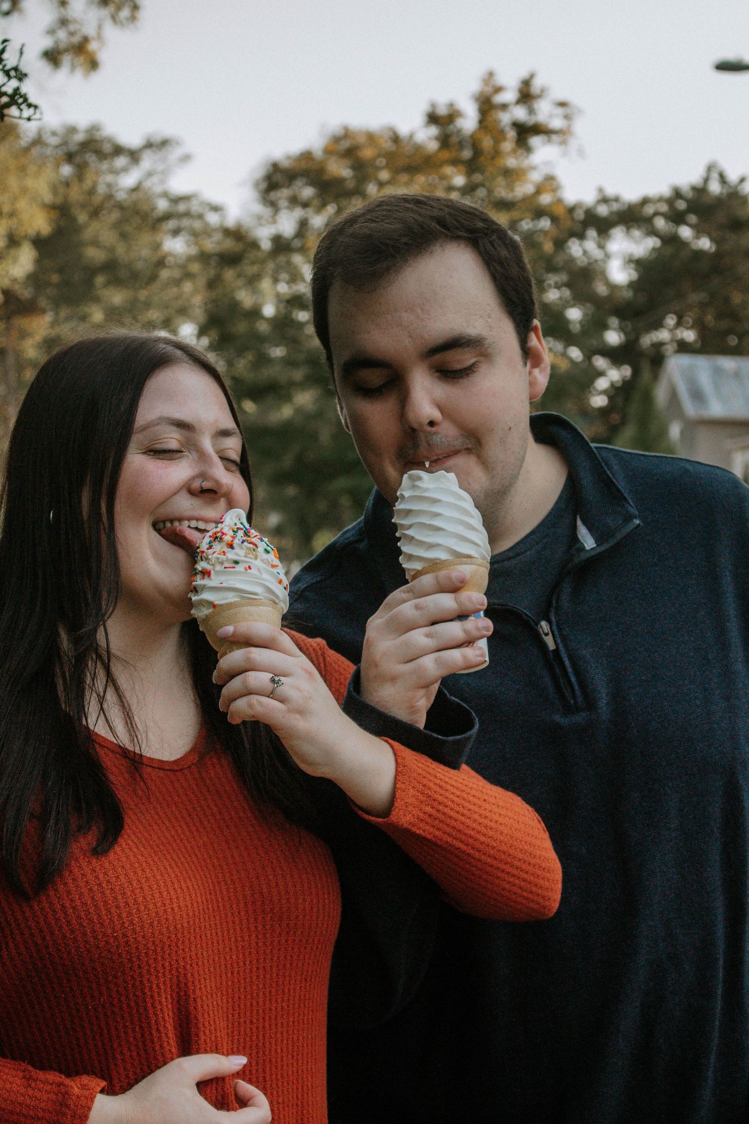 Happy couple sharing ice cream cones with sprinkles outdoors, smiling in Downtown Yellow Springs, Ohio