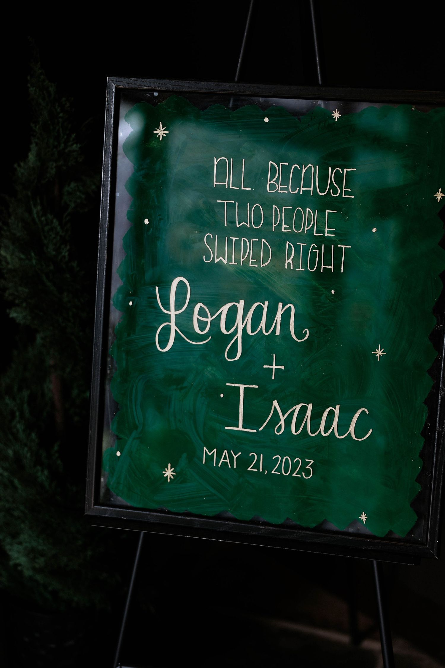 Green wedding welcome sign on easel reading Logan and Isaac May 21 2023 with Tinder swiped right quote.