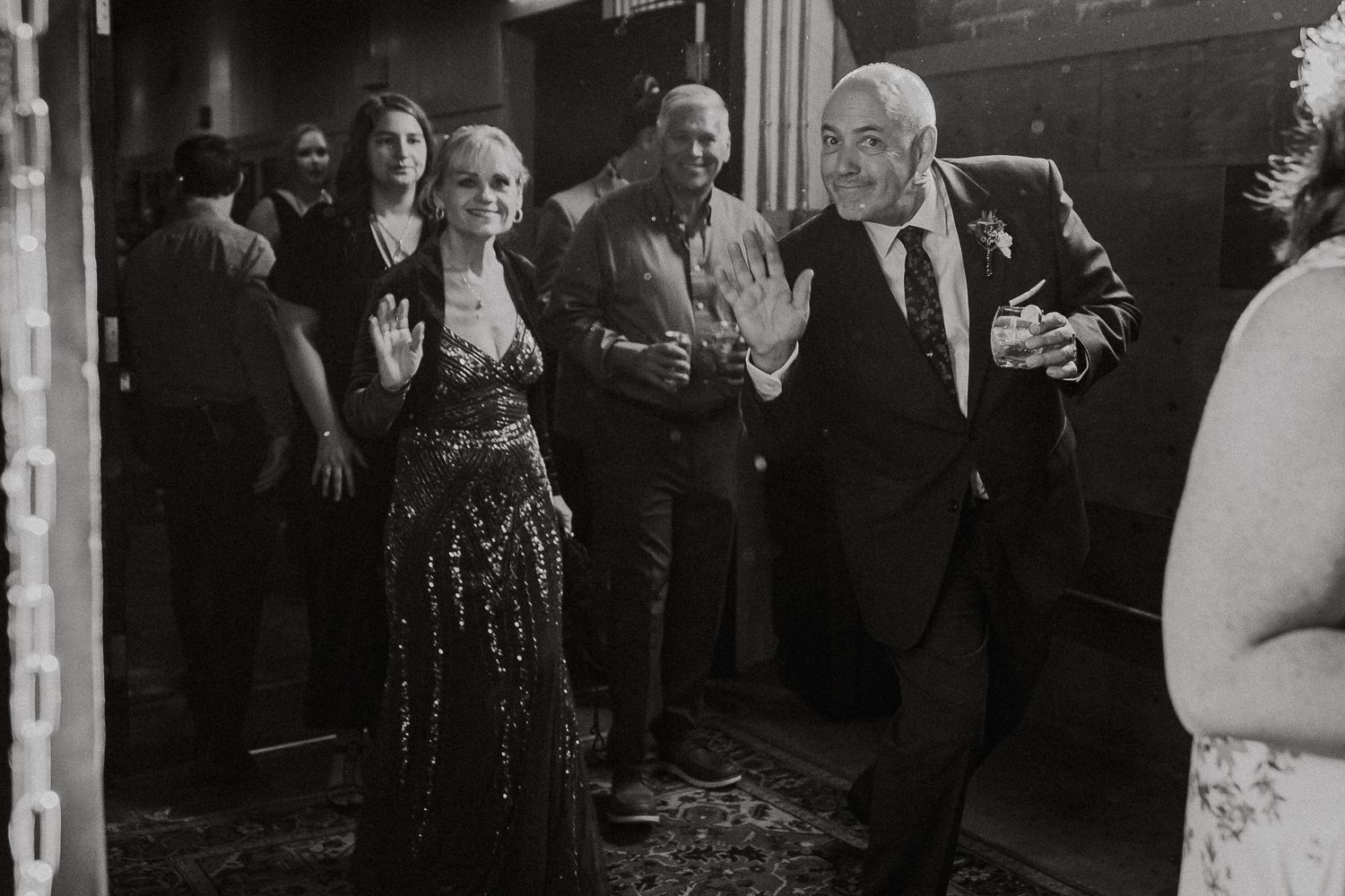 Guests making a grand entrance at a wedding reception in black and white photography.