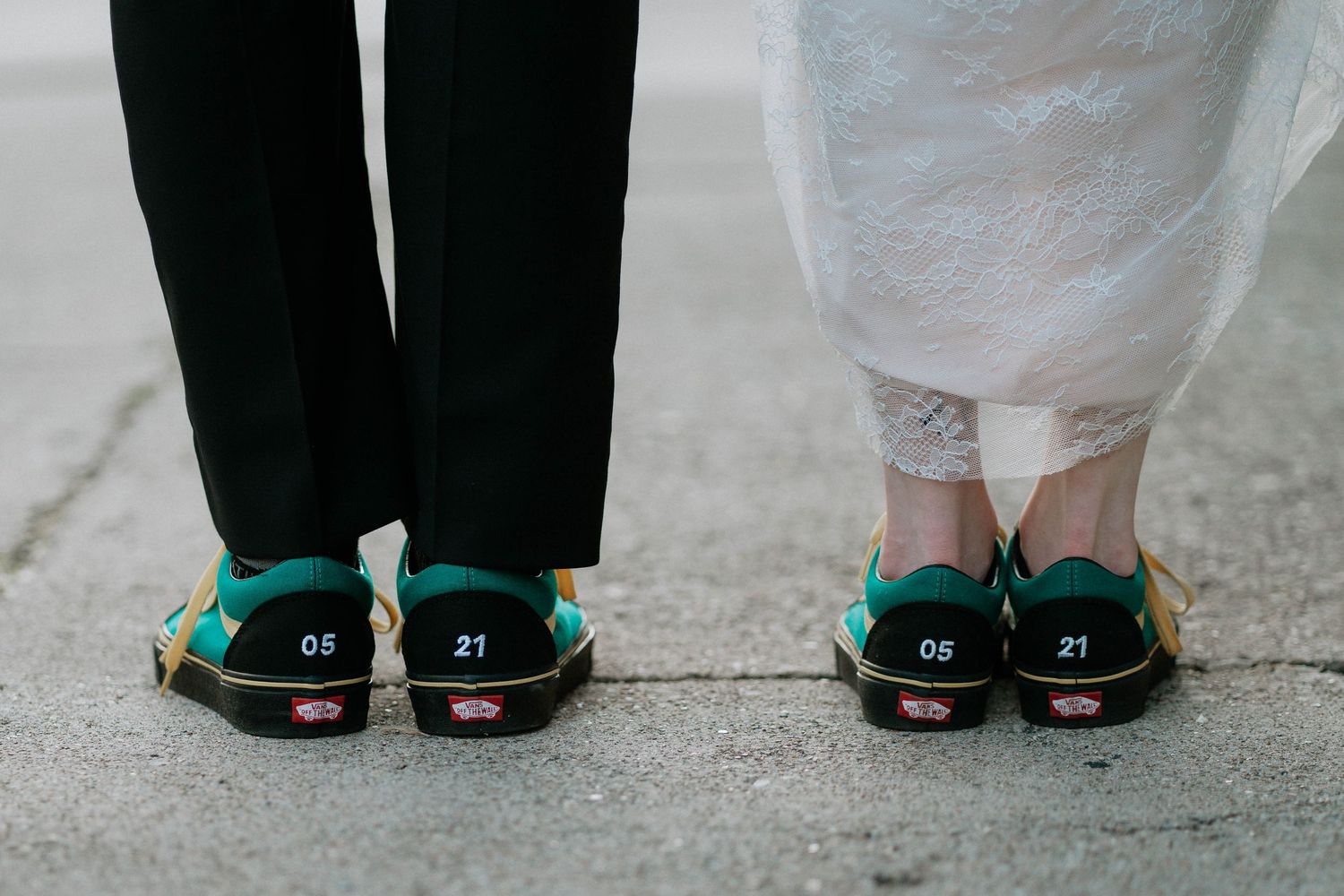 Couple wearing matching green Vans sneakers with wedding date numbers at their wedding ceremony.