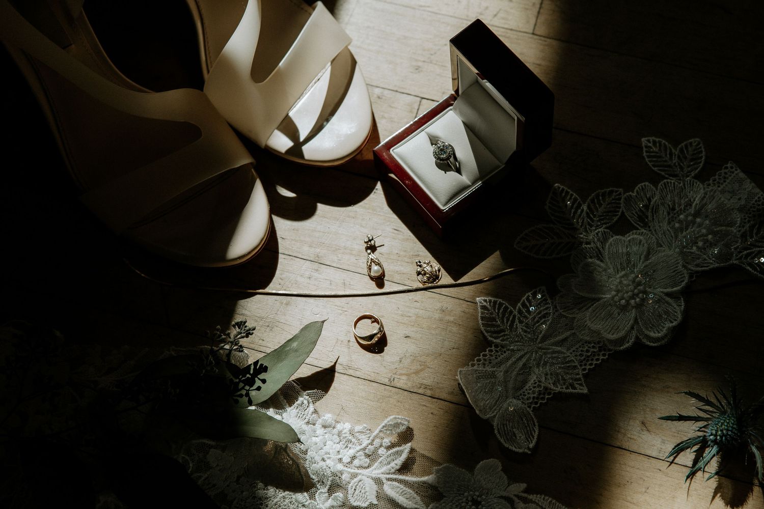 Wedding details flatlay with bridal heels, rings, earrings, and lace on wooden floor at Urban Artifact in Cincinnati, Ohio