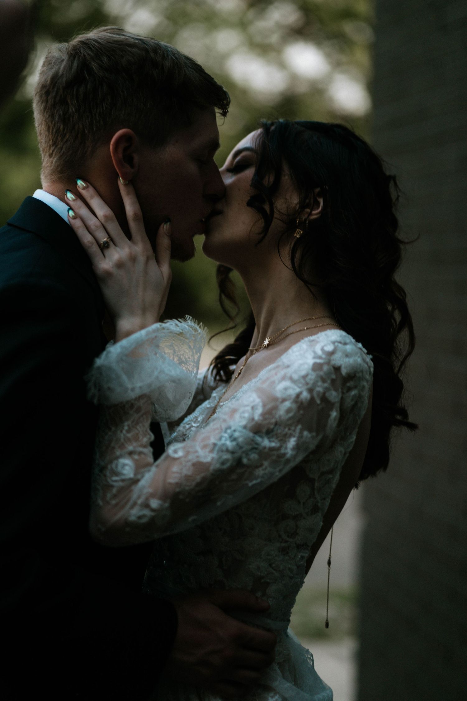 A bride and groom share a romantic kiss outdoors in moody, soft natural lighting at The Brightside in Dayton, Ohio