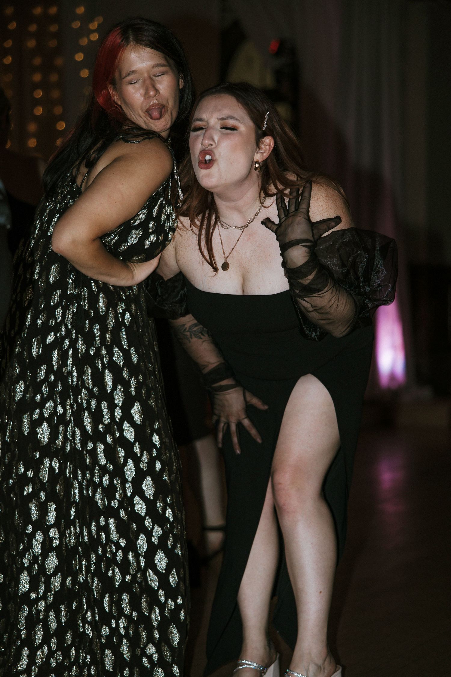 Two women in black dresses dancing and making silly faces at wedding reception in Cincinnati, Ohio