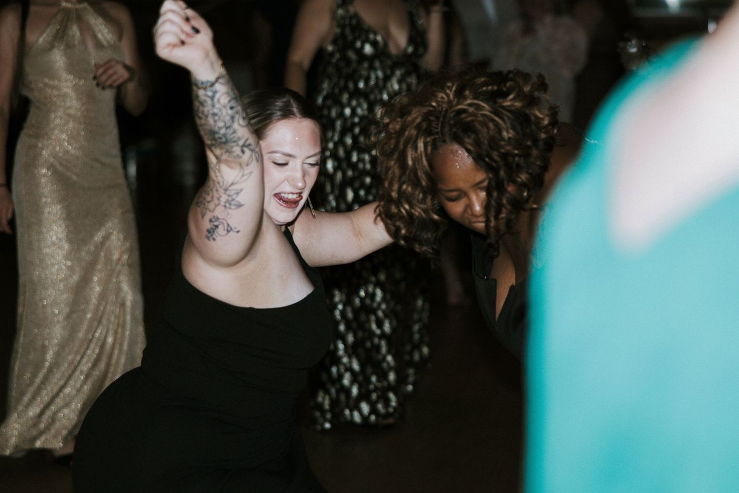 Two women dancing joyfully together under lights at wedding reception in Cincinnati, Ohio